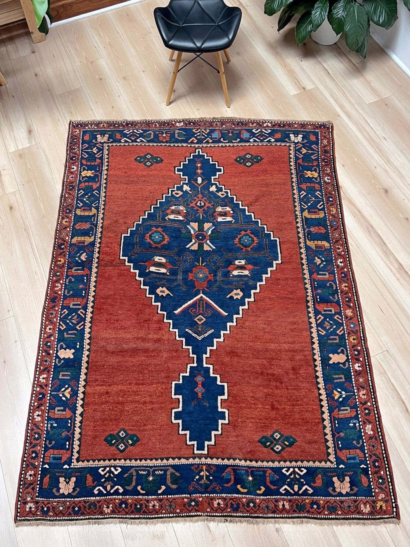 5x7 Vintage Caucasian scatter rug with a terracotta field and a bold midnight blue geometric medallion, accented with melon, ivory, and baby blue motifs. From  the best rug shop san francisco bay area Burlingame CA free shiping