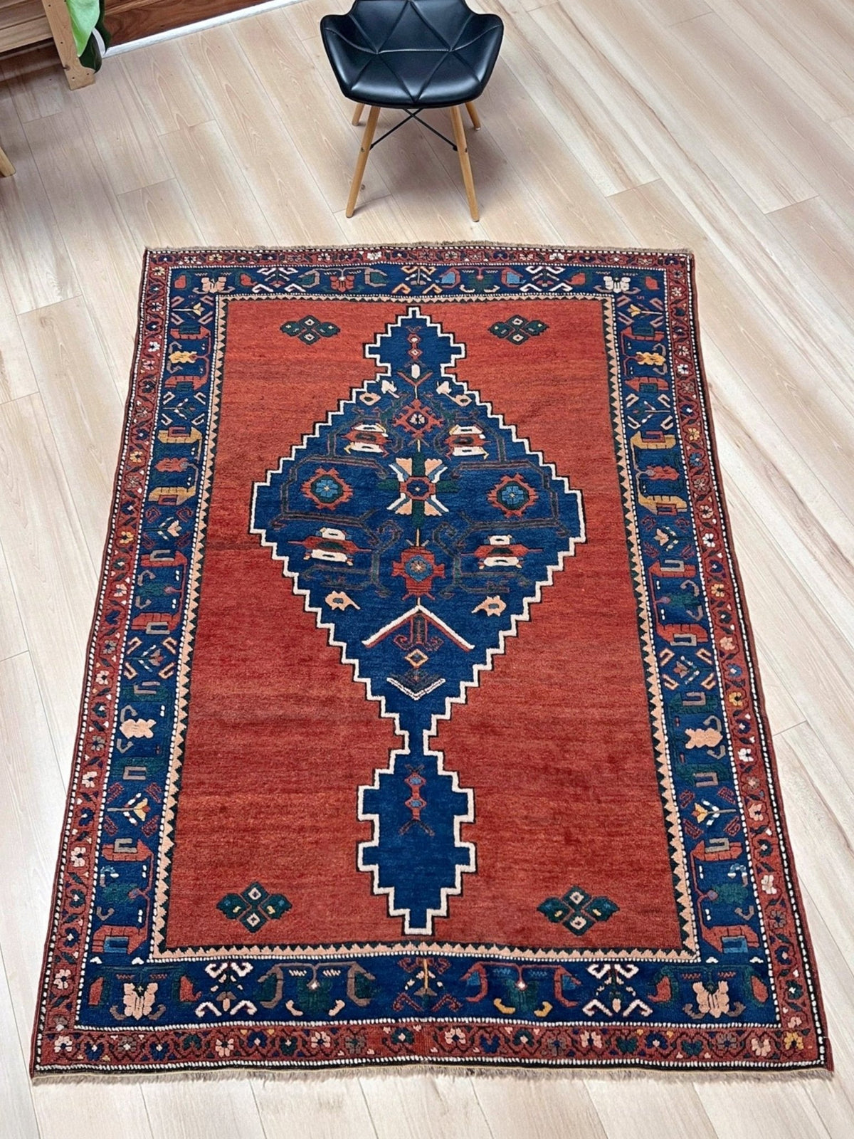 5x7 Vintage Caucasian rug with a terracotta red field and a bold midnight blue geometric medallion. From  the best rug shop san francisco bay area Burlingame CA
