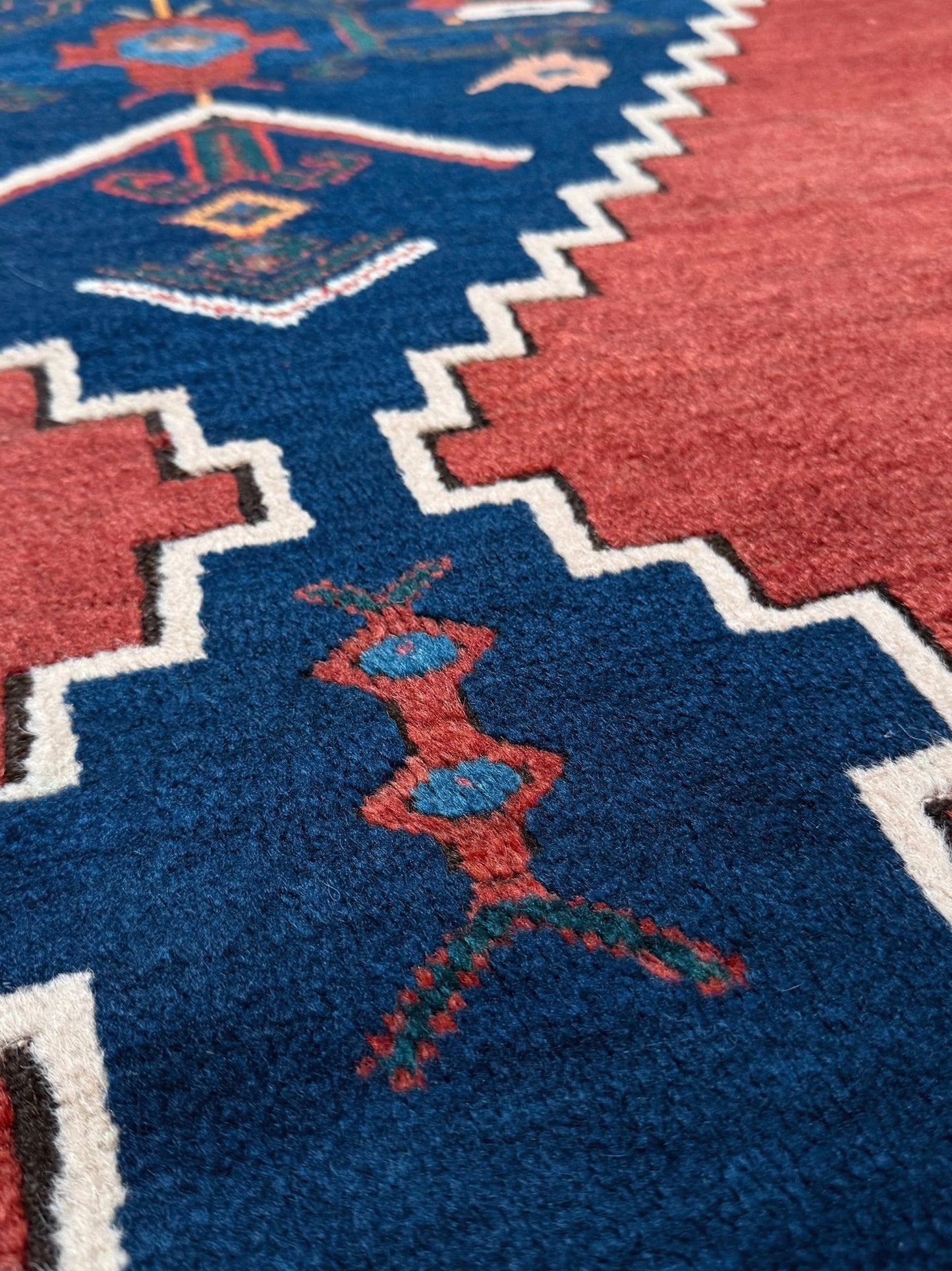 5x7 Vintage Caucasian scatter rug with a terracotta field and a bold midnight blue geometric medallion, accented with melon, ivory, and baby blue motifs. From  the best rug shop san francisco bay area Burlingame CA free shiping