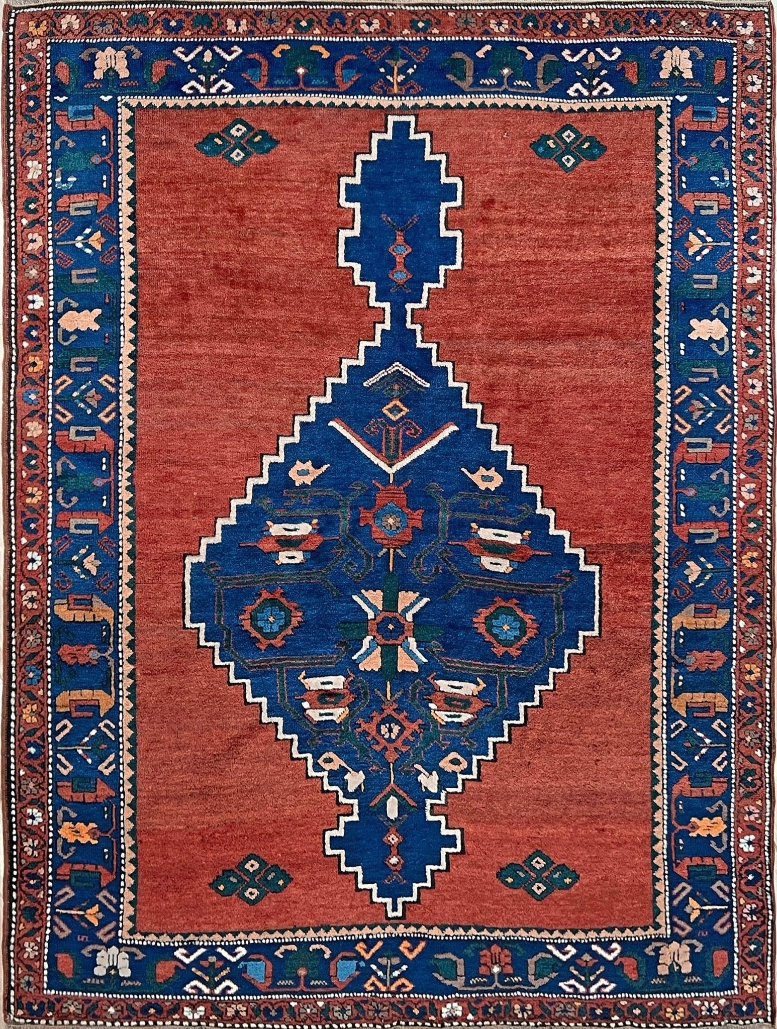 5x7 Vintage Caucasian scatter rug with a terracotta field and a bold midnight blue geometric medallion, accented with melon, ivory, and baby blue motifs. From  the best rug shop san francisco bay area Burlingame CA free shiping