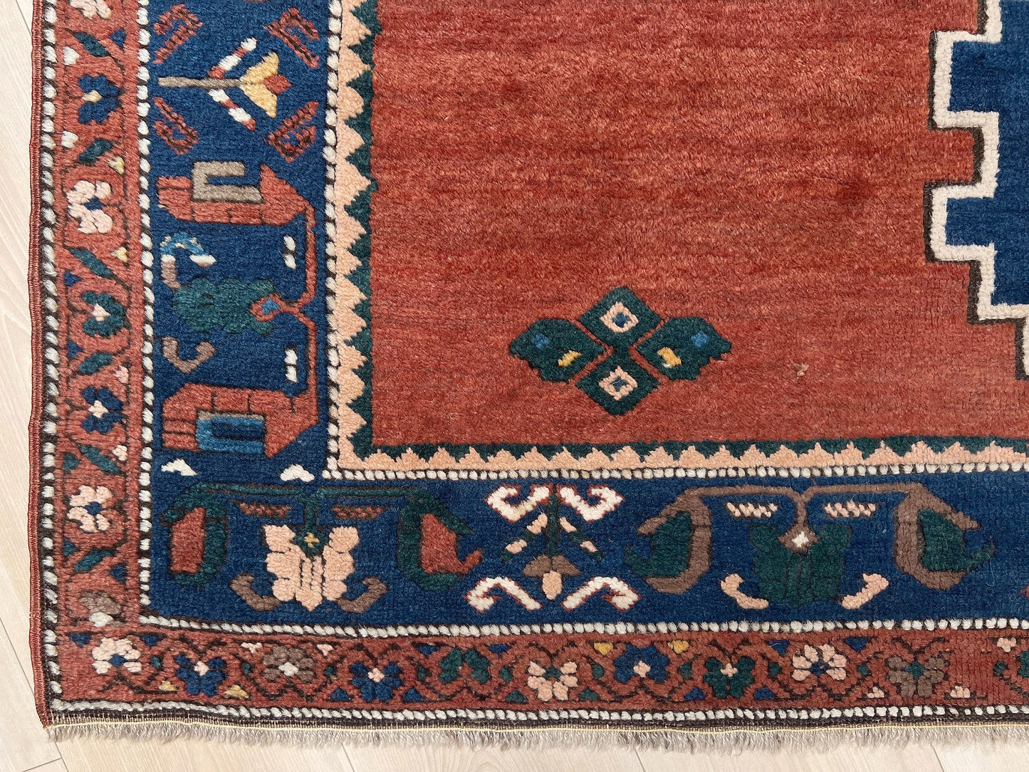 5x7 Vintage Caucasian scatter rug with a terracotta field and a bold midnight blue geometric medallion, accented with melon, ivory, and baby blue motifs. From  the best rug shop san francisco bay area Burlingame CA free shiping