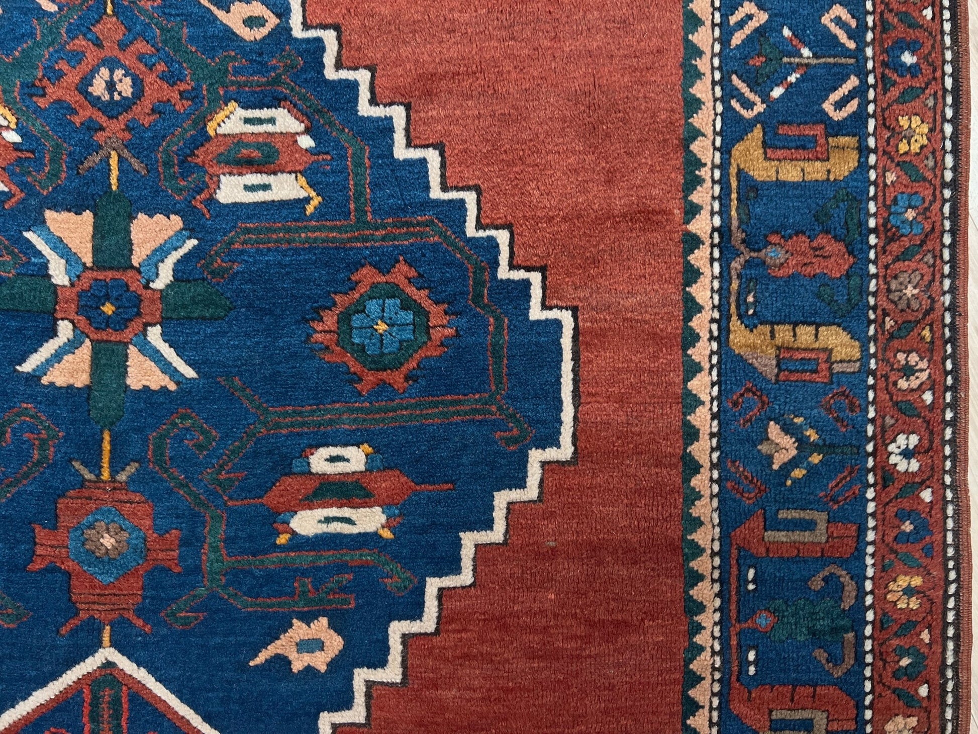 5x7 Vintage Caucasian scatter rug with a terracotta field and a bold midnight blue geometric medallion, accented with melon, ivory, and baby blue motifs. From  the best rug shop san francisco bay area Burlingame CA free shiping