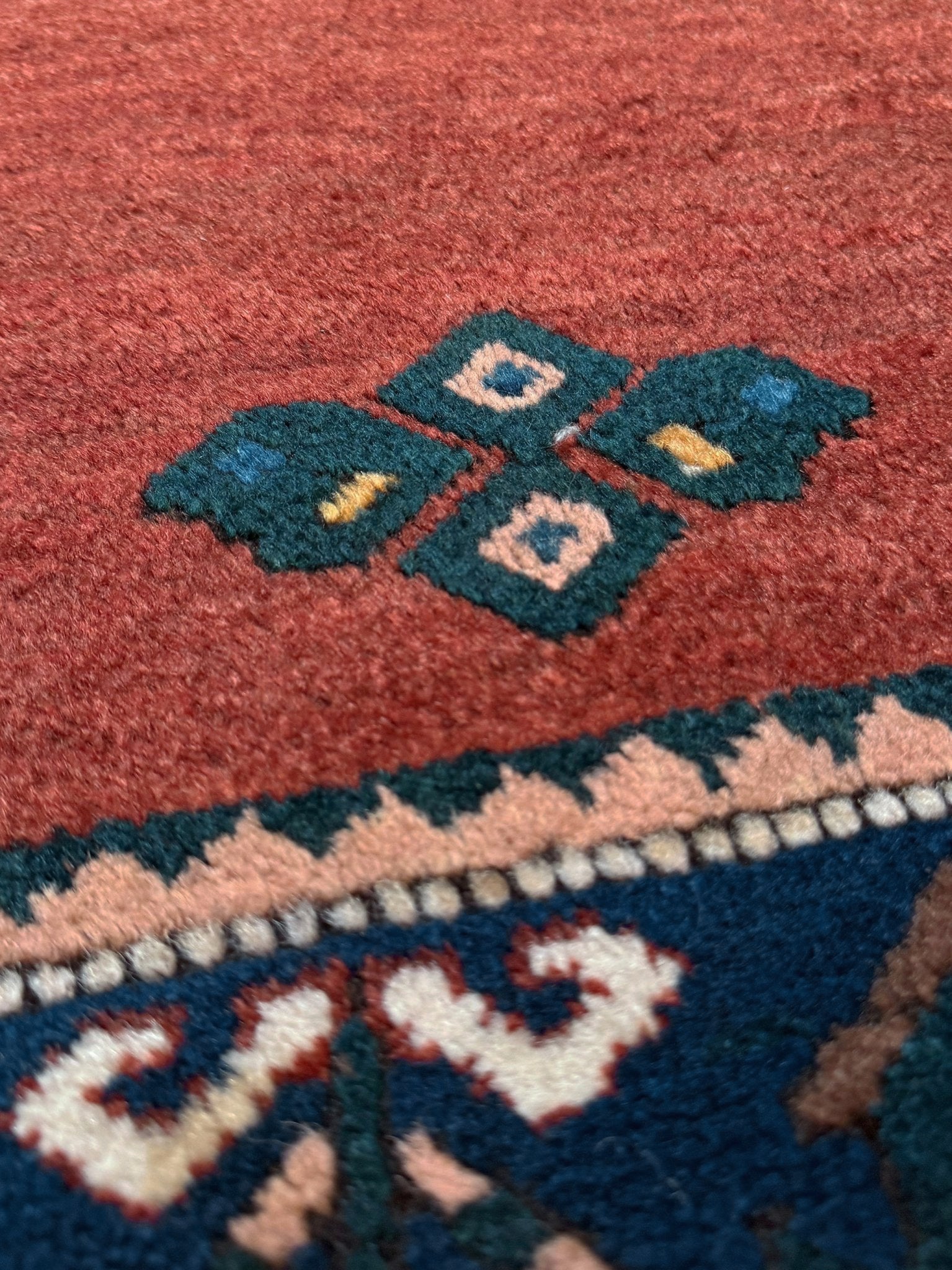 5x7 Vintage Caucasian scatter rug with a terracotta field and a bold midnight blue geometric medallion, accented with melon, ivory, and baby blue motifs. From  the best rug shop san francisco bay area Burlingame CA free shiping