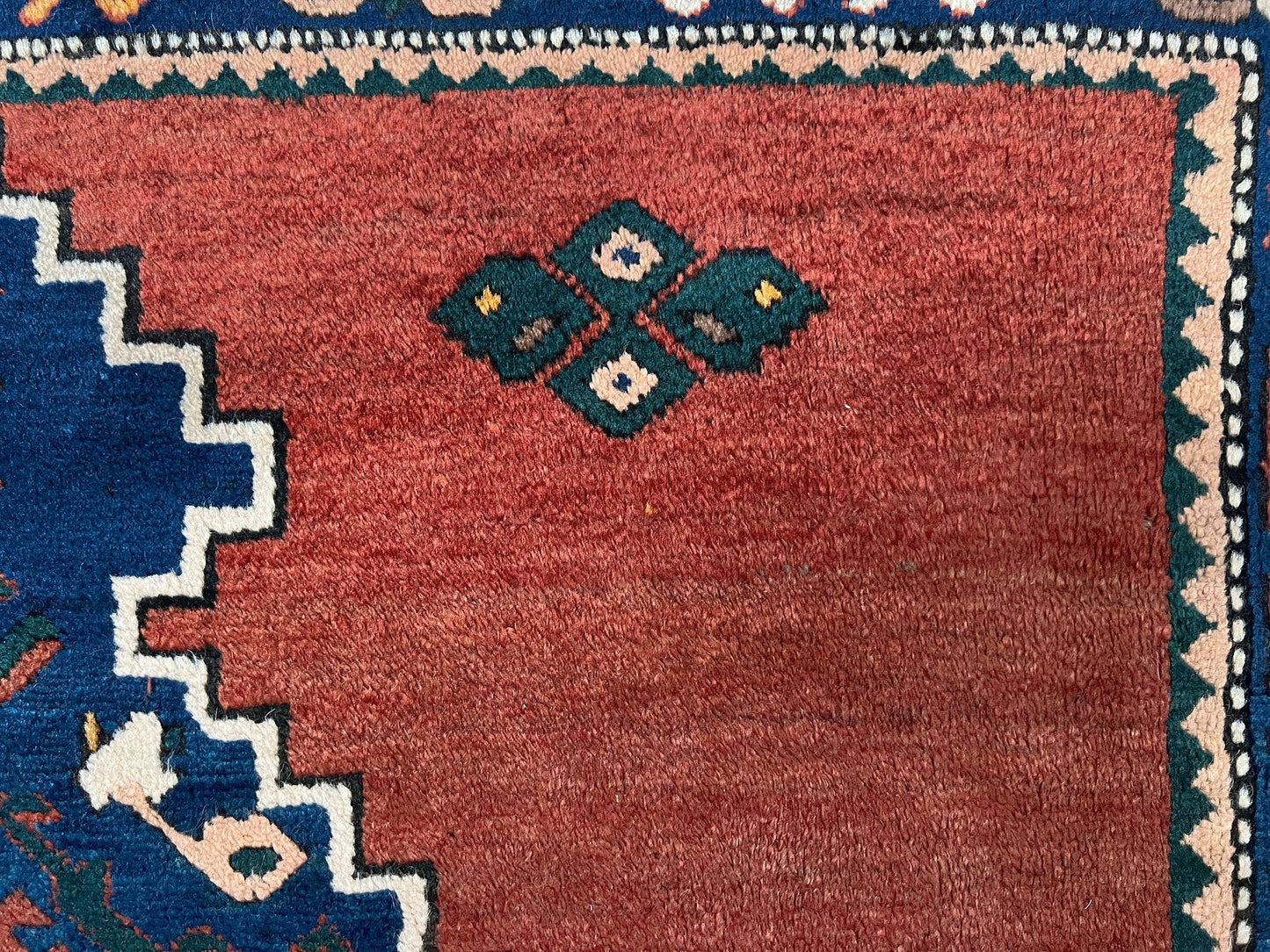 5x7 Vintage Caucasian scatter rug with a terracotta field and a bold midnight blue geometric medallion, accented with melon, ivory, and baby blue motifs. From  the best rug shop san francisco bay area Burlingame CA free shiping