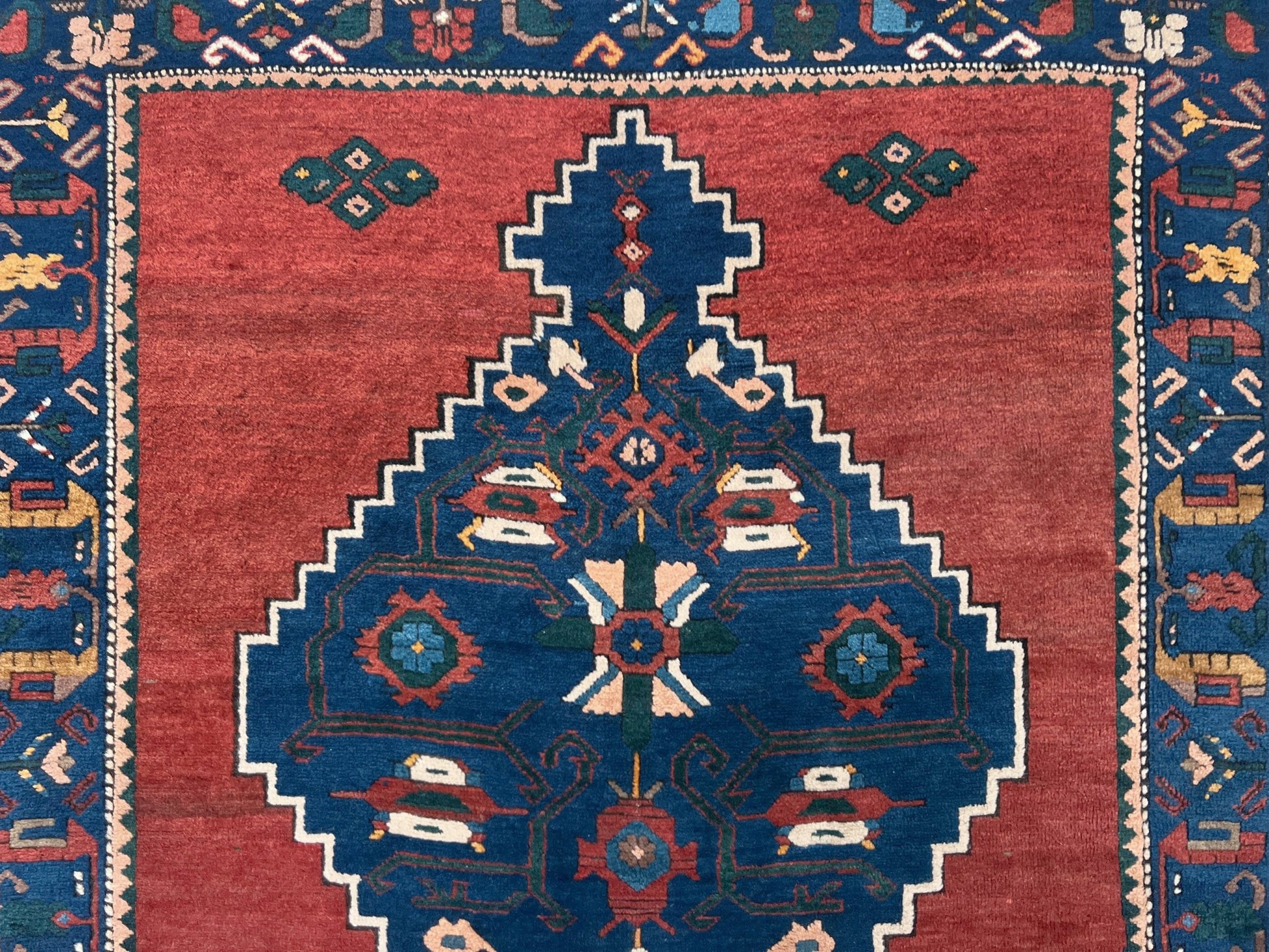 5x7 Vintage Caucasian scatter rug with a terracotta field and a bold midnight blue geometric medallion, accented with melon, ivory, and baby blue motifs. From  the best rug shop san francisco bay area Burlingame CA free shiping
