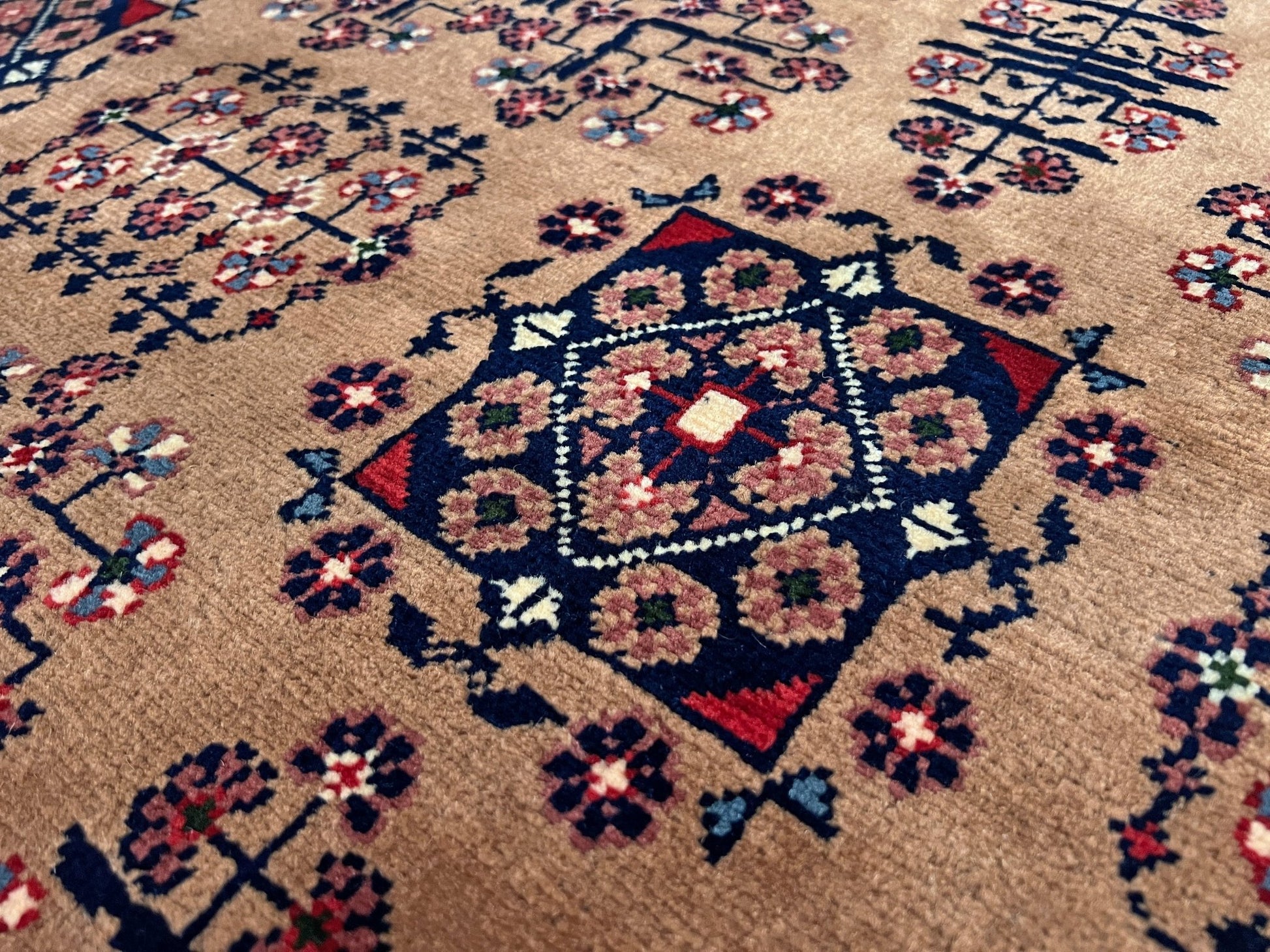 Close up Sand Bilcik Turkmen wool area rug with intricate medallion motifs and ornate indigo and rust borders, perfect for living room, bedroom, or dining room decor. Sold by the best handmade luxury rug shop in the San Francisco Bay Area.