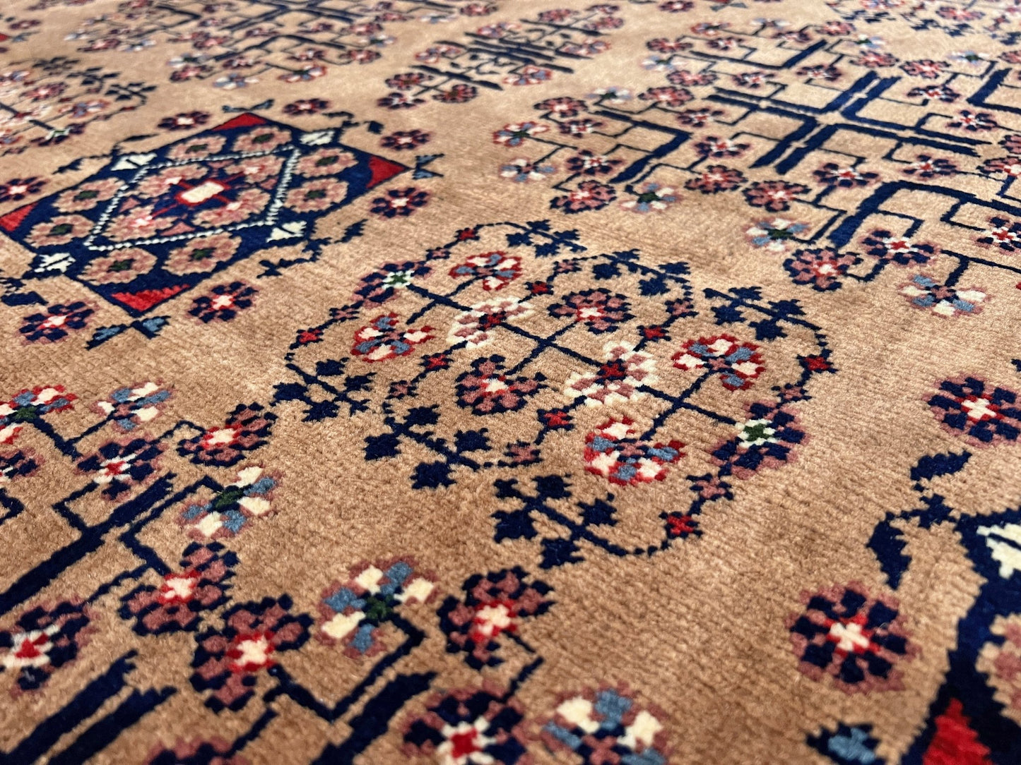 Close up Sand Bilcik Turkmen wool area rug with intricate medallion motifs and ornate indigo and rust borders, perfect for living room, bedroom, or dining room decor. Sold by the best handmade luxury rug shop in the San Francisco Bay Area.