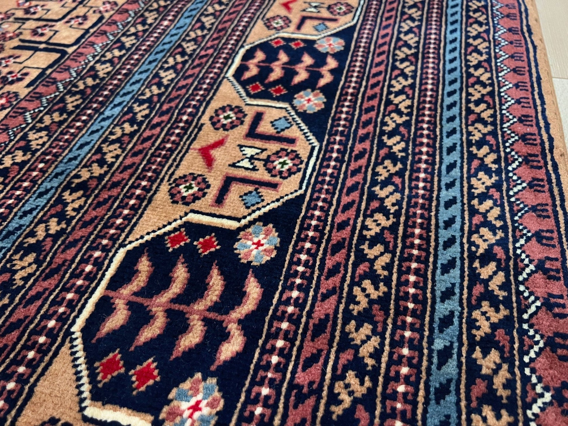 Close up Sand Bilcik Turkmen wool area rug with intricate medallion motifs and ornate indigo and rust borders, perfect for living room, bedroom, or dining room decor. Sold by the best handmade luxury rug shop in the San Francisco Bay Area.