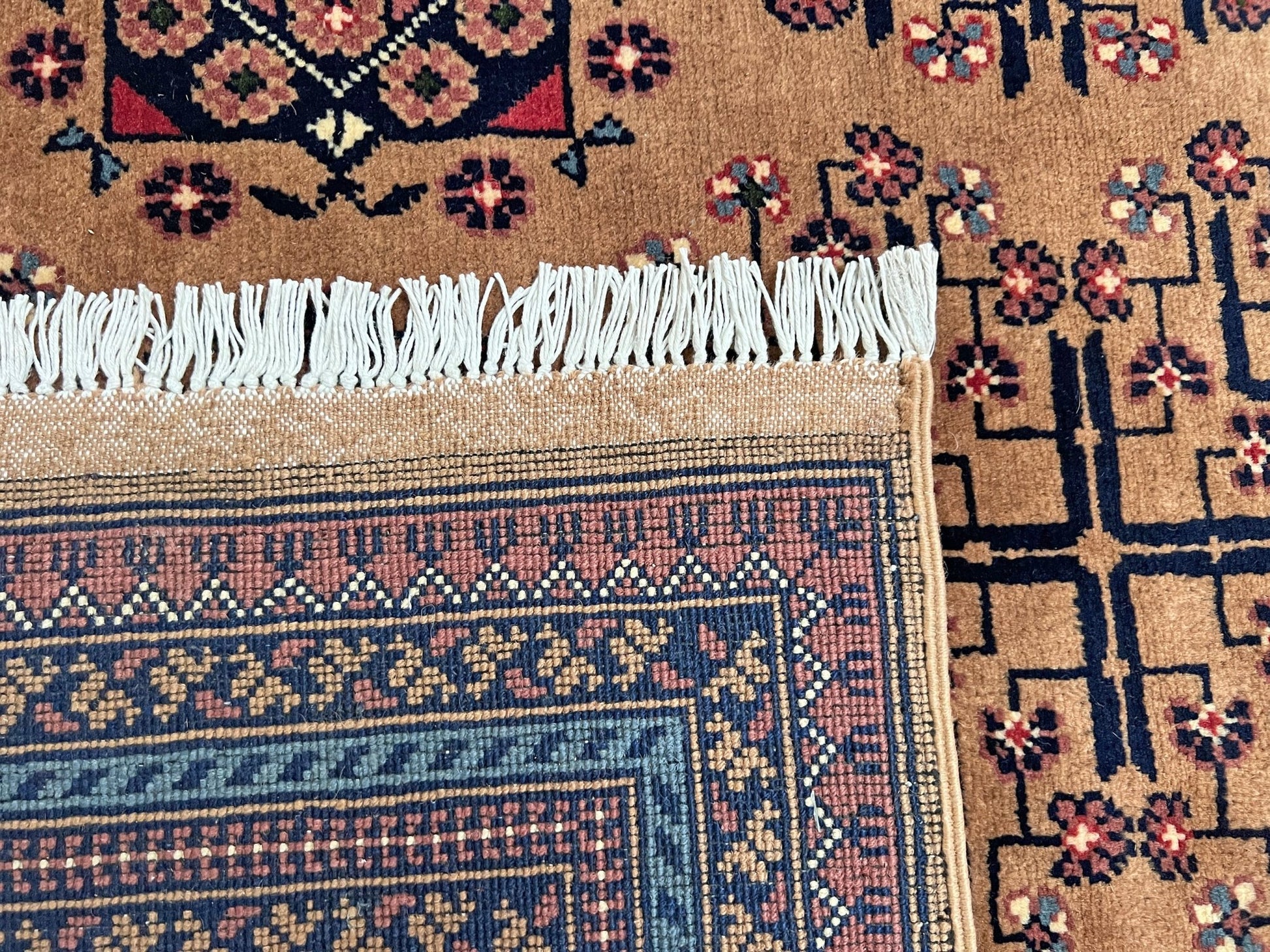 Back detail of Sand Bilcik Turkmen wool area rug with intricate medallion motifs and ornate indigo and rust borders, perfect for living room, bedroom, or dining room decor. Sold by the best handmade luxury rug shop in the San Francisco Bay Area.