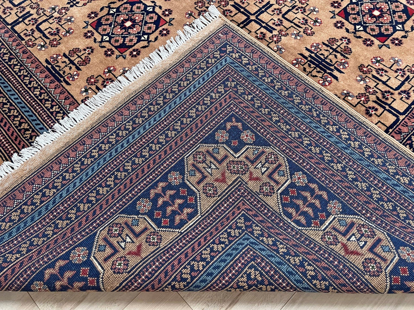 Back of Sand Bilcik Turkmen wool area rug with intricate medallion motifs and ornate indigo and rust borders, perfect for living room, bedroom, or dining room decor. Sold by the best handmade luxury rug shop in the San Francisco Bay Area.