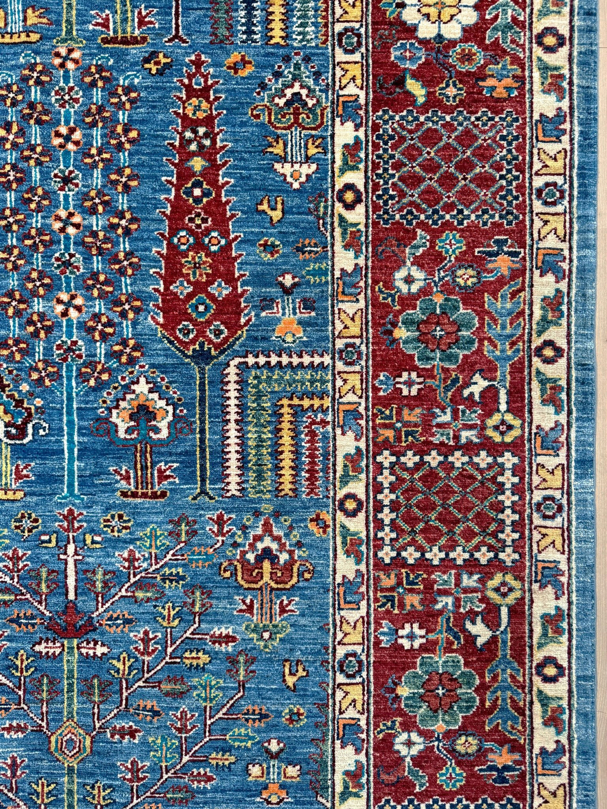 9x12 Tree of Life rug with sky blue field, deep crimson border, cypress trees, floral motifs, handmade wool from Indigo Rugs Burlingame Bay Area.