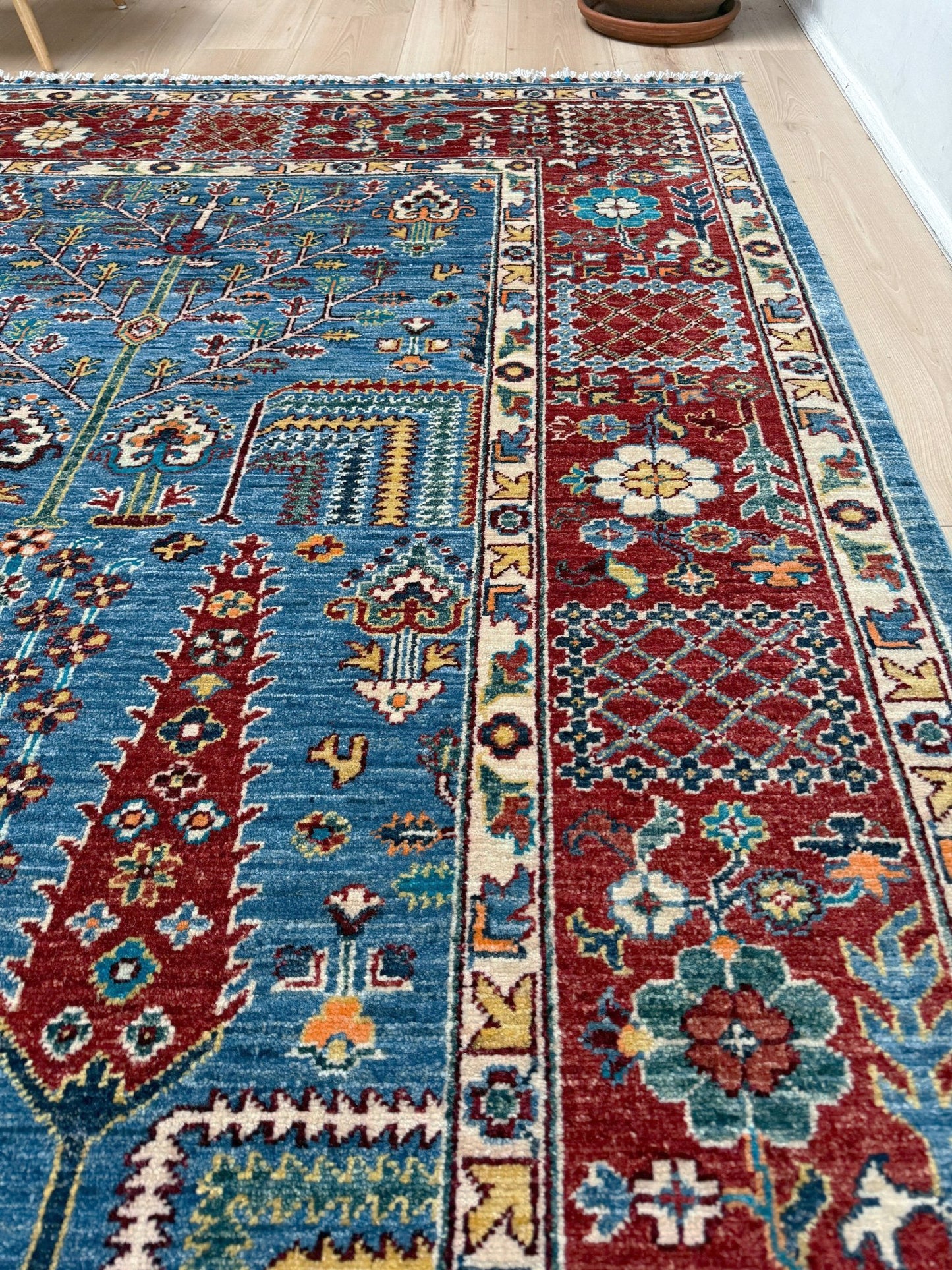 9x12 Tree of Life rug with sky blue field, deep crimson border, cypress trees, floral motifs, handmade wool from Indigo Rugs Burlingame Bay Area.