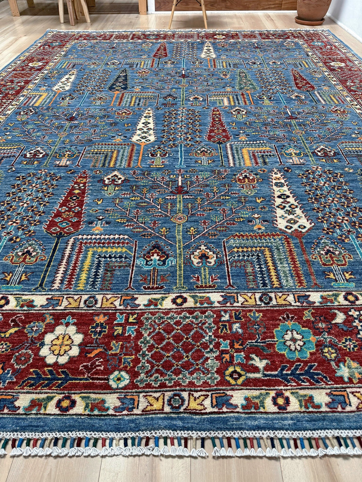 Blue Tree of Life 9x12 rug with sky blue field, deep crimson border, cypress trees, floral motifs, handmade wool from Indigo Rugs Burlingame Bay Area.