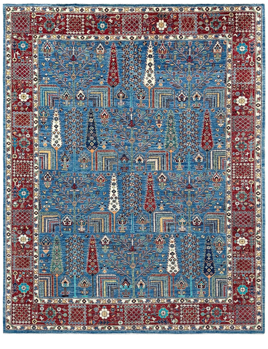 A traditional Persian-style area rug with a complex geometric and floral pattern, featuring a dominant blue center field, a deep red border, and cream accents. Blue Tree of Life 9x12 rug with sky blue field, deep crimson border, cypress trees, floral motifs, handmade wool from Indigo Rugs Burlingame Bay Area.