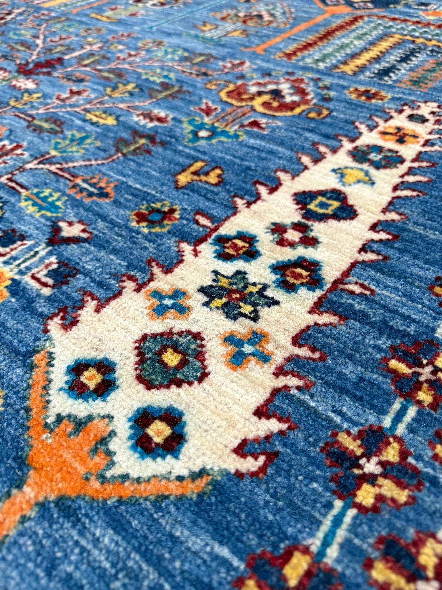 Close-up of Brand new 9x12 Tree of Life Turkish rug – sky blue with deep crimson red, ivory, and gold accents. Perfect for bedroom, living room, or dining area. High-quality, handmade wool rug from the best rug shop in San Mateo, SF Bay Area. Free shipping available.