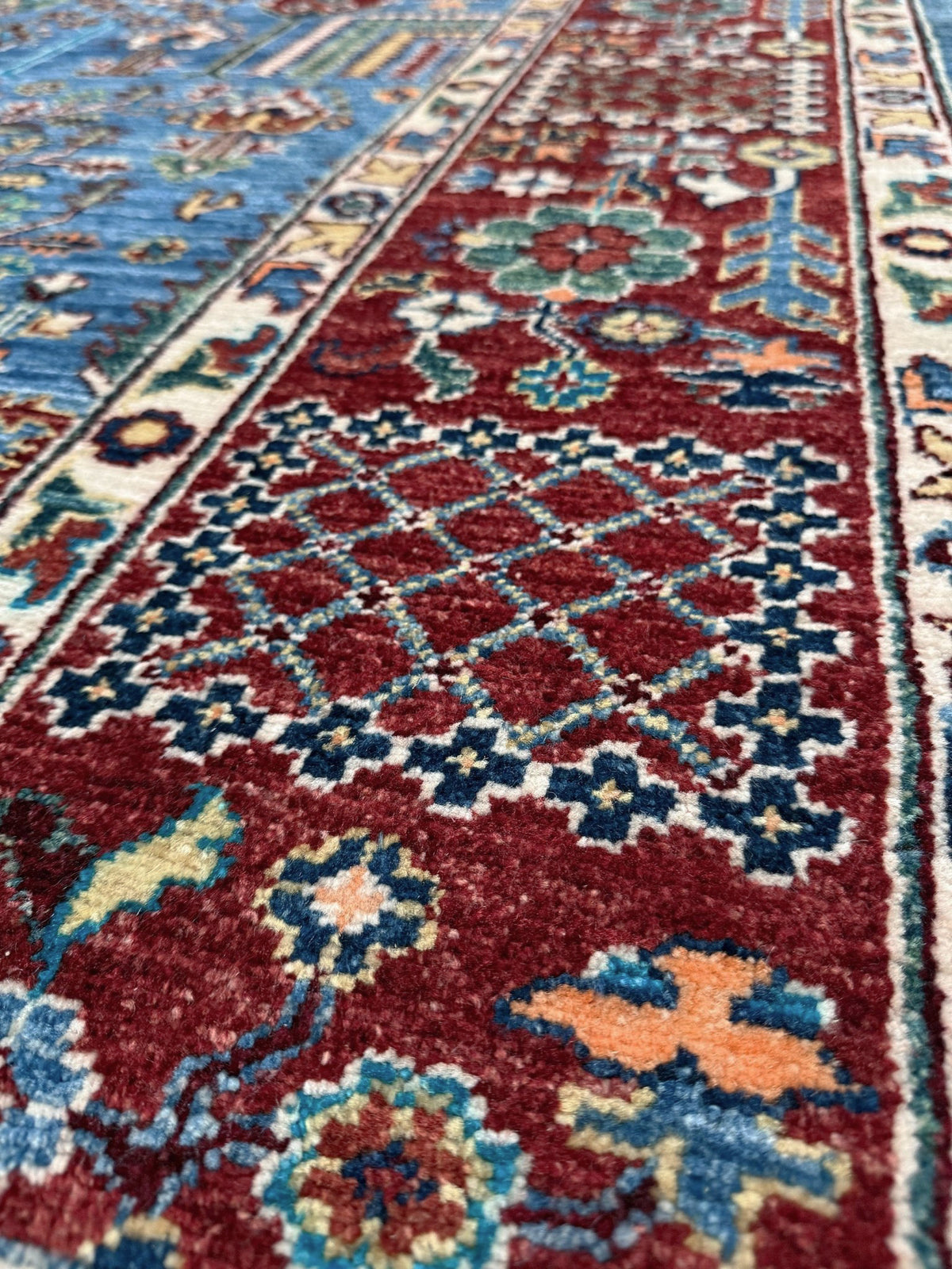 9x12 Tree of Life rug with sky blue field, deep crimson border, cypress trees, floral motifs, handmade wool from Indigo Rugs Burlingame Bay Area.