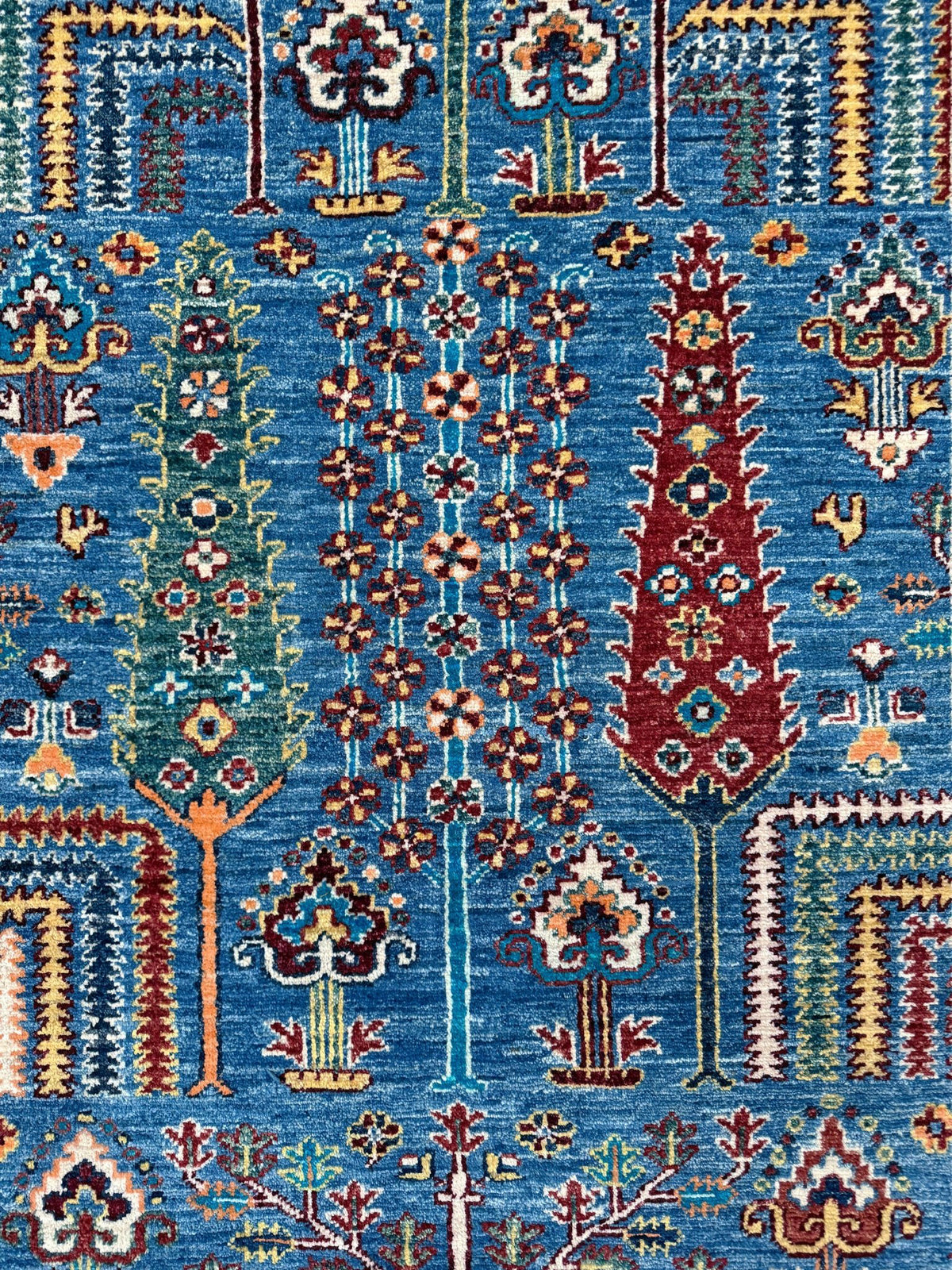9x12 Tree of Life rug with sky blue field, deep crimson border, cypress trees, floral motifs, handmade wool from Indigo Rugs Burlingame Bay Area.