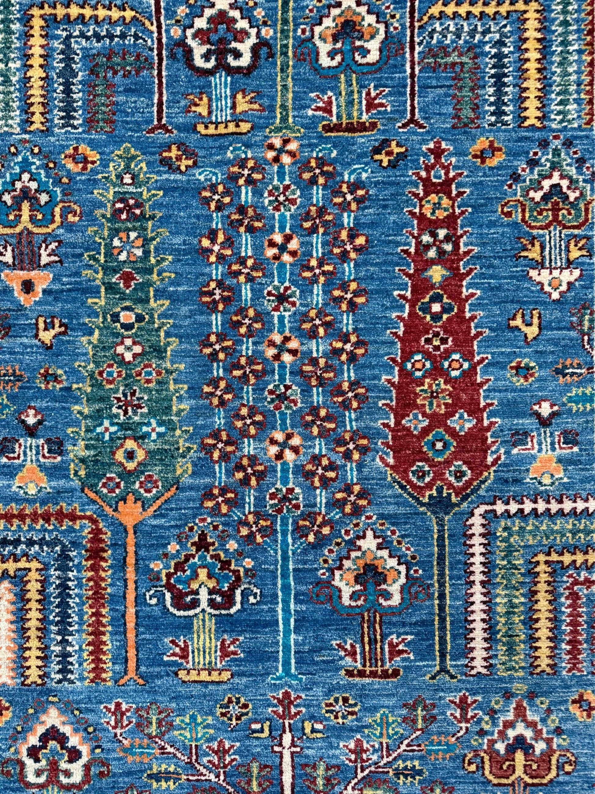 9x12 Tree of Life rug with sky blue field, deep crimson border, cypress trees, floral motifs, handmade wool from Indigo Rugs Burlingame Bay Area.