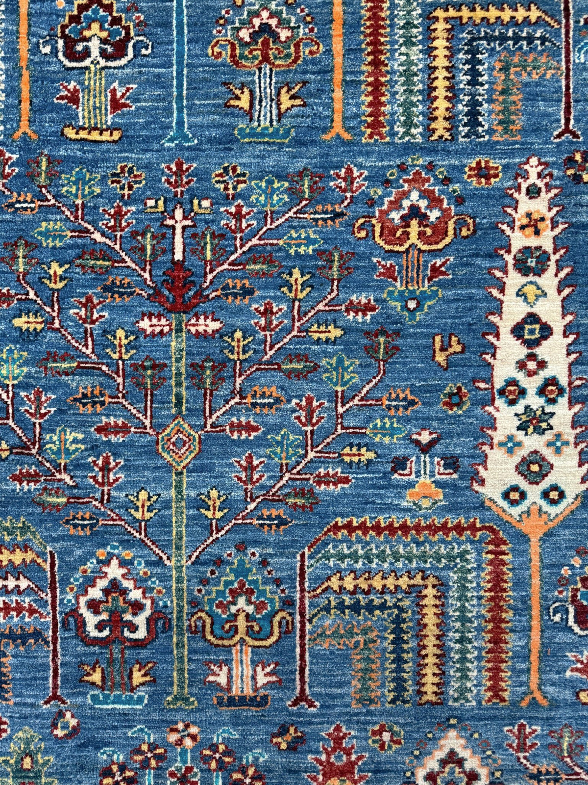 9x12 Tree of Life rug with sky blue field, deep crimson border, cypress trees, floral motifs, handmade wool from Indigo Rugs Burlingame Bay Area.