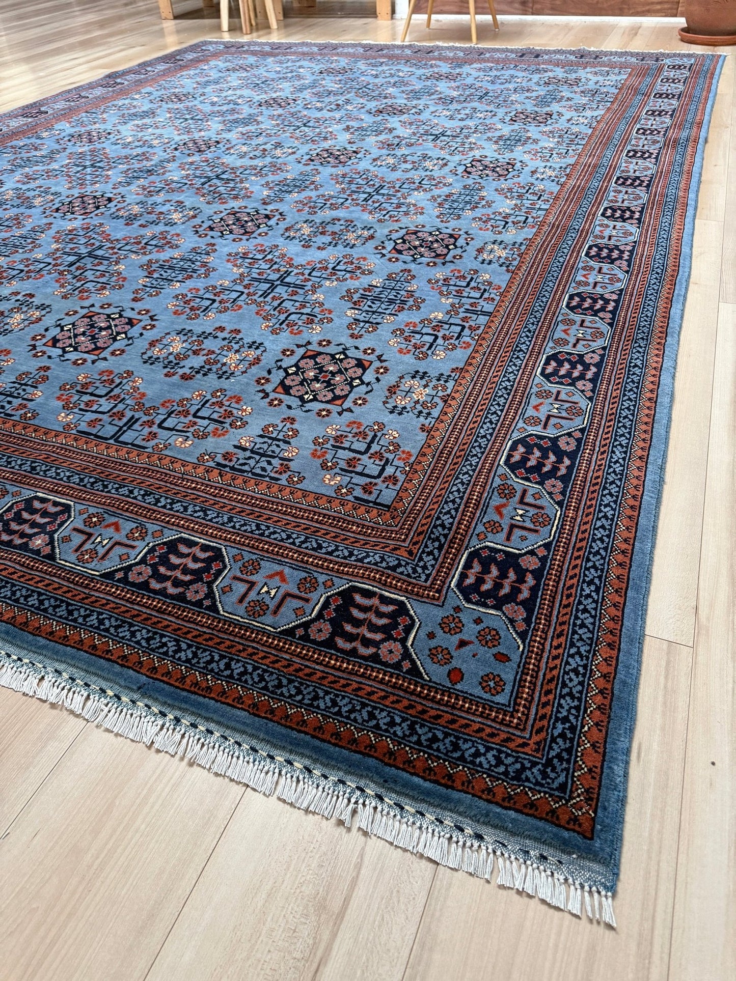9x12 Handmade Turkmen rug with a baby blue ground, featuring traditional geometric motifs in brown, midnight blue, terracotta crafted from silky Merino wool with a luxurious sheen, available with free shipping from the best handmade rug shop Burlingame CA San Francisco Bay Area.