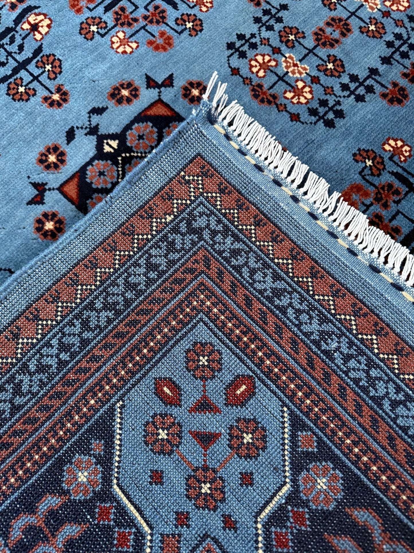 9x12 Handmade Turkmen rug with a baby blue ground, featuring traditional geometric motifs in brown, midnight blue, terracotta crafted from silky Merino wool with a luxurious sheen, available with free shipping from the best handmade rug shop Burlingame CA San Francisco Bay Area.