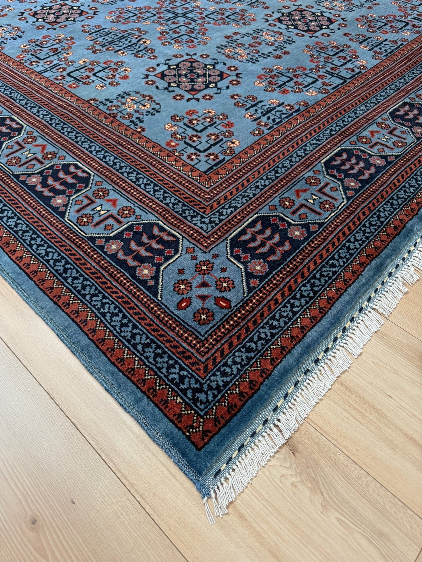 9x12 Handmade Turkmen rug with a baby blue ground, featuring traditional geometric motifs in brown, midnight blue, terracotta crafted from silky Merino wool with a luxurious sheen, available with free shipping from the best handmade rug shop Burlingame CA San Francisco Bay Area.