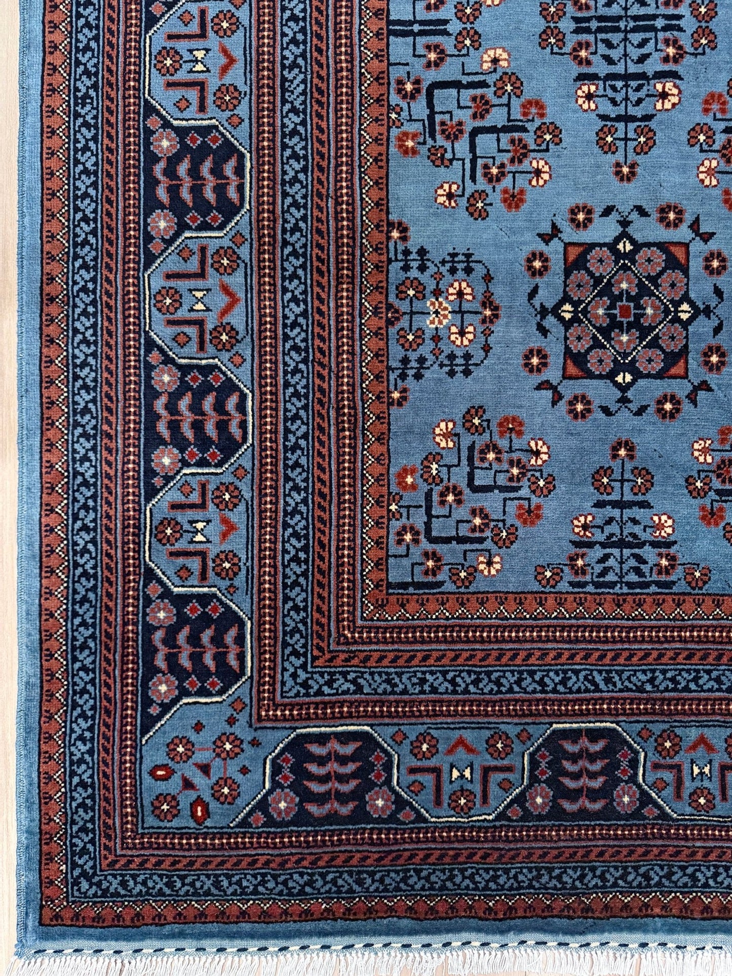 9x12 Handmade Turkmen rug with a baby blue ground, featuring traditional geometric motifs in brown, midnight blue, terracotta crafted from silky Merino wool with a luxurious sheen, available with free shipping from the best handmade rug shop Burlingame CA San Francisco Bay Area.