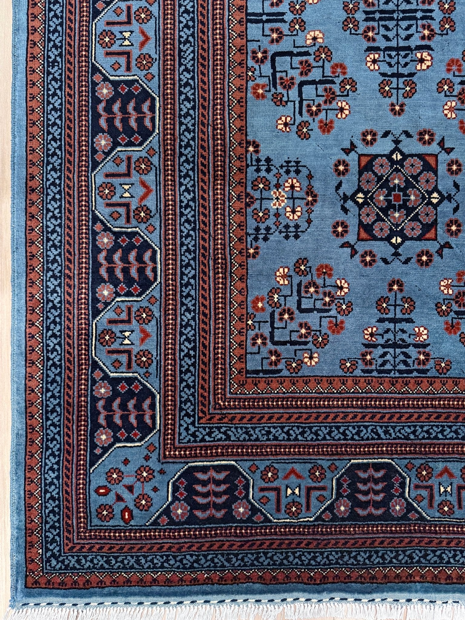 9x12 Handmade Turkmen rug with a baby blue ground, featuring traditional geometric motifs in brown, midnight blue, terracotta crafted from silky Merino wool with a luxurious sheen, available with free shipping from the best handmade rug shop Burlingame CA San Francisco Bay Area.