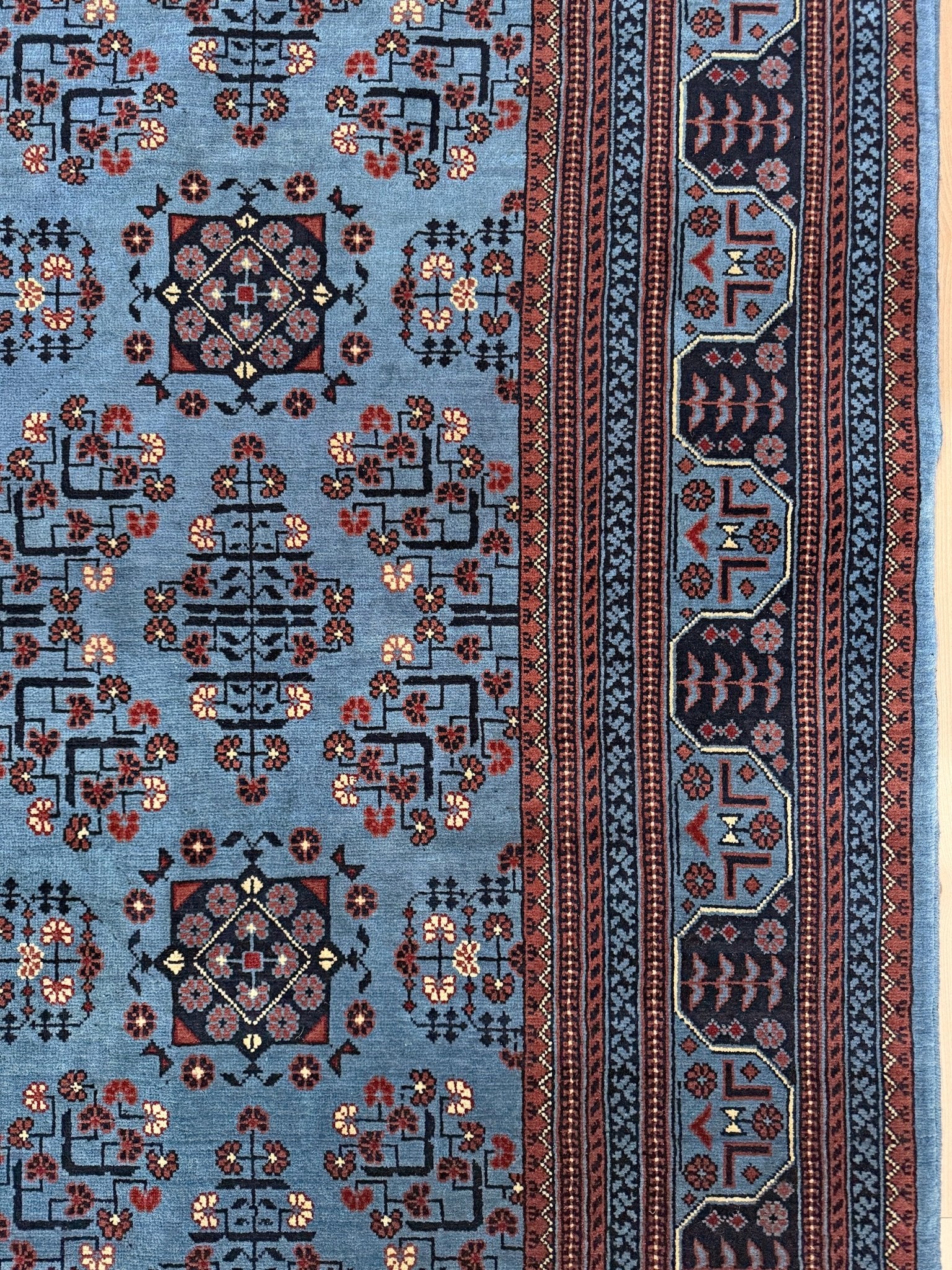 9x12 Handmade Turkmen rug with a baby blue ground, featuring traditional geometric motifs in brown, midnight blue, terracotta crafted from silky Merino wool with a luxurious sheen, available with free shipping from the best handmade rug shop Burlingame CA San Francisco Bay Area.