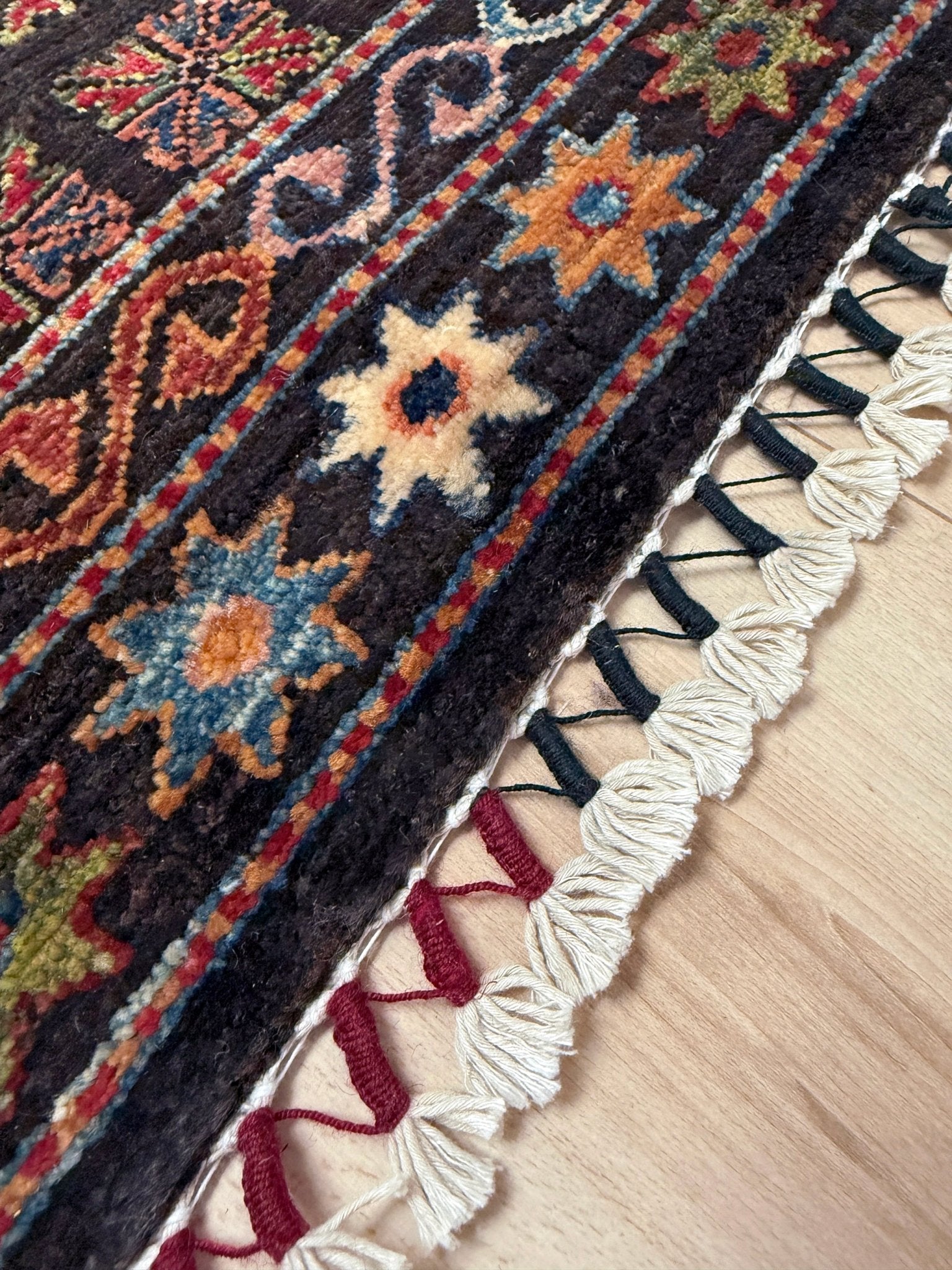 Handmade Turkmen-style 9x12 wool rug with Caucasian-inspired design, rich black, crimson, ivory, and sage hues. Luxury area rug with intricate medallions and floral motifs, perfect for bedroom, living room, or dining room. High-quality craftsmanship from the best rug shop in Burlingame CA, SF Bay Area. Free shipping, timeless character, and elegance for any space.