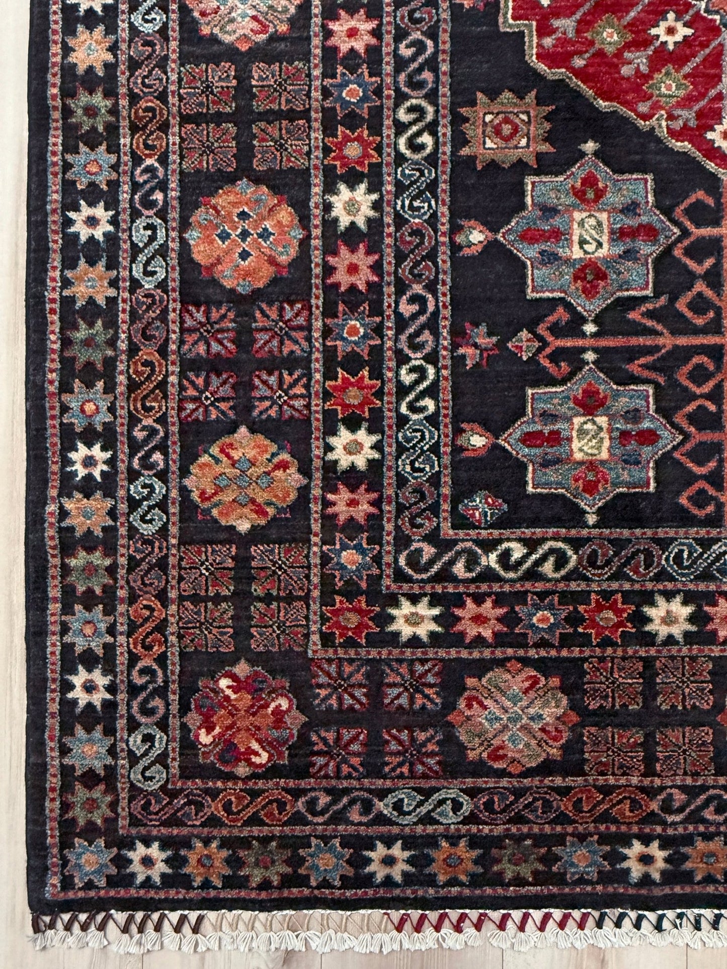 Handmade Turkmen-style 9x12 wool rug with Caucasian-inspired design, rich black, crimson, ivory, and sage hues. Luxury area rug with intricate medallions and floral motifs, perfect for bedroom, living room, or dining room. High-quality craftsmanship from the best rug shop in Burlingame CA, SF Bay Area. Free shipping, timeless character, and elegance for any space.