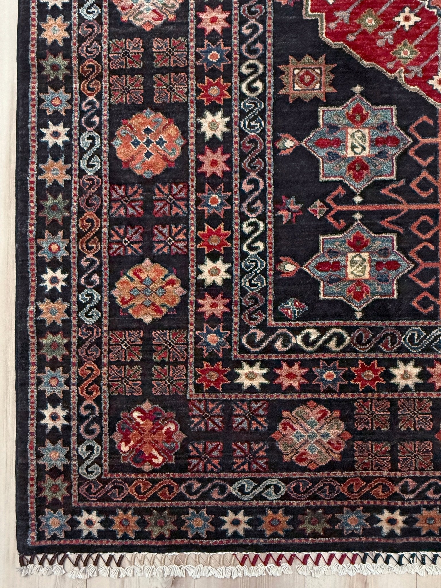 Handmade Turkmen-style 9x12 wool rug with Caucasian-inspired design, rich black, crimson, ivory, and sage hues. Luxury area rug with intricate medallions and floral motifs, perfect for bedroom, living room, or dining room. High-quality craftsmanship from the best rug shop in Burlingame CA, SF Bay Area. Free shipping, timeless character, and elegance for any space.
