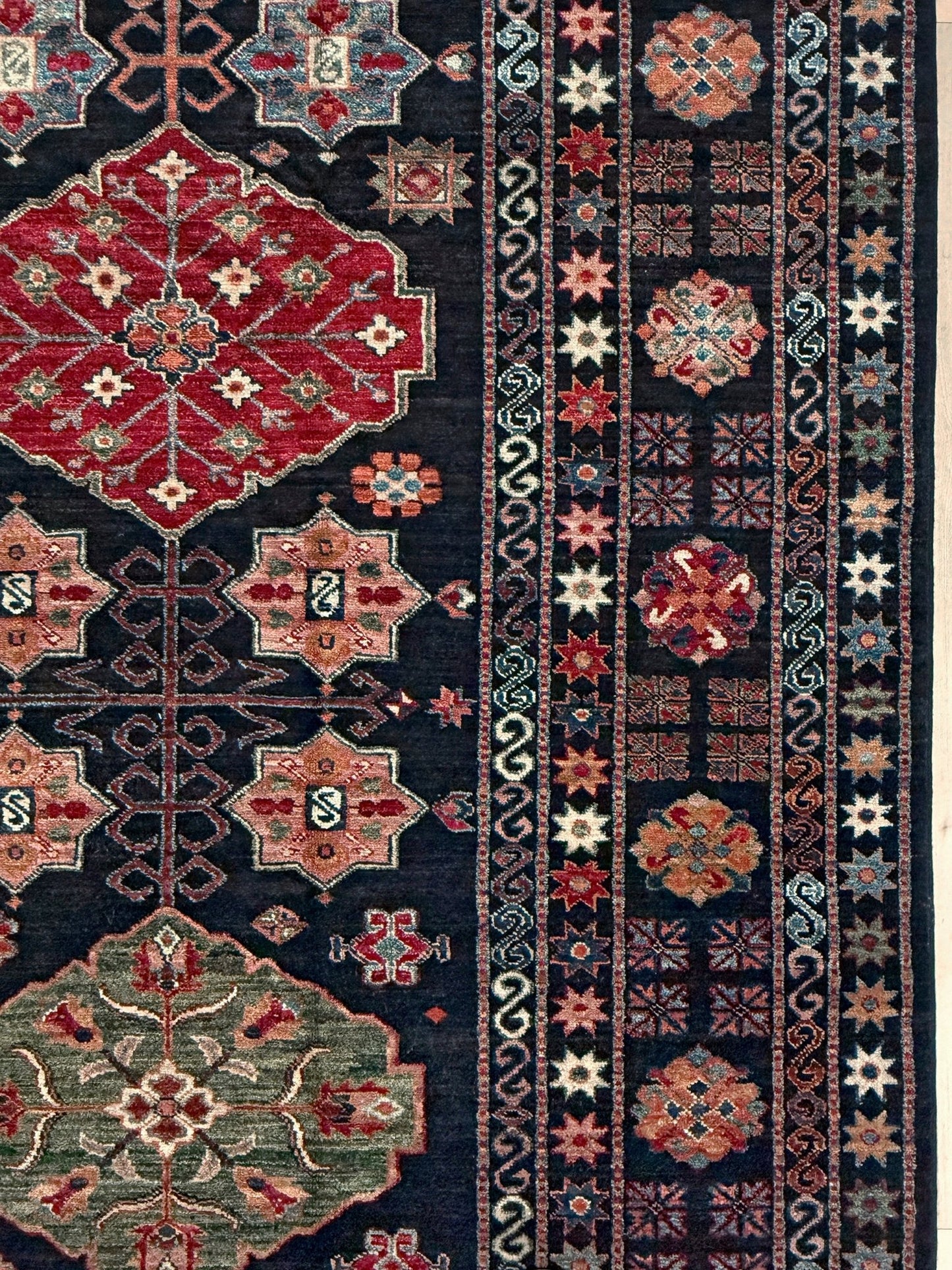Handmade Turkmen-style 9x12 wool rug with Caucasian-inspired design, rich black, crimson, ivory, and sage hues. Luxury area rug with intricate medallions and floral motifs, perfect for bedroom, living room, or dining room. High-quality craftsmanship from the best rug shop in Burlingame CA, SF Bay Area. Free shipping, timeless character, and elegance for any space.