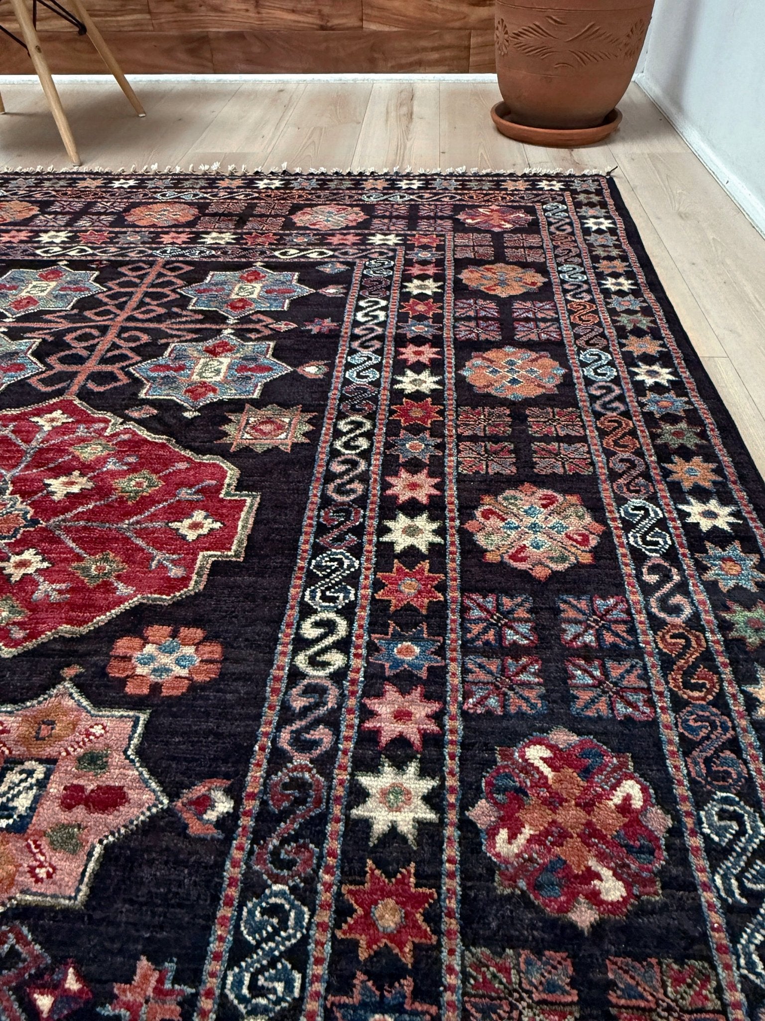 Handmade Turkmen-style 9x12 wool rug with Caucasian-inspired design, rich black, crimson, ivory, and sage hues. Luxury area rug with intricate medallions and floral motifs, perfect for bedroom, living room, or dining room. High-quality craftsmanship from the best rug shop in Burlingame CA, SF Bay Area. Free shipping, timeless character, and elegance for any space.