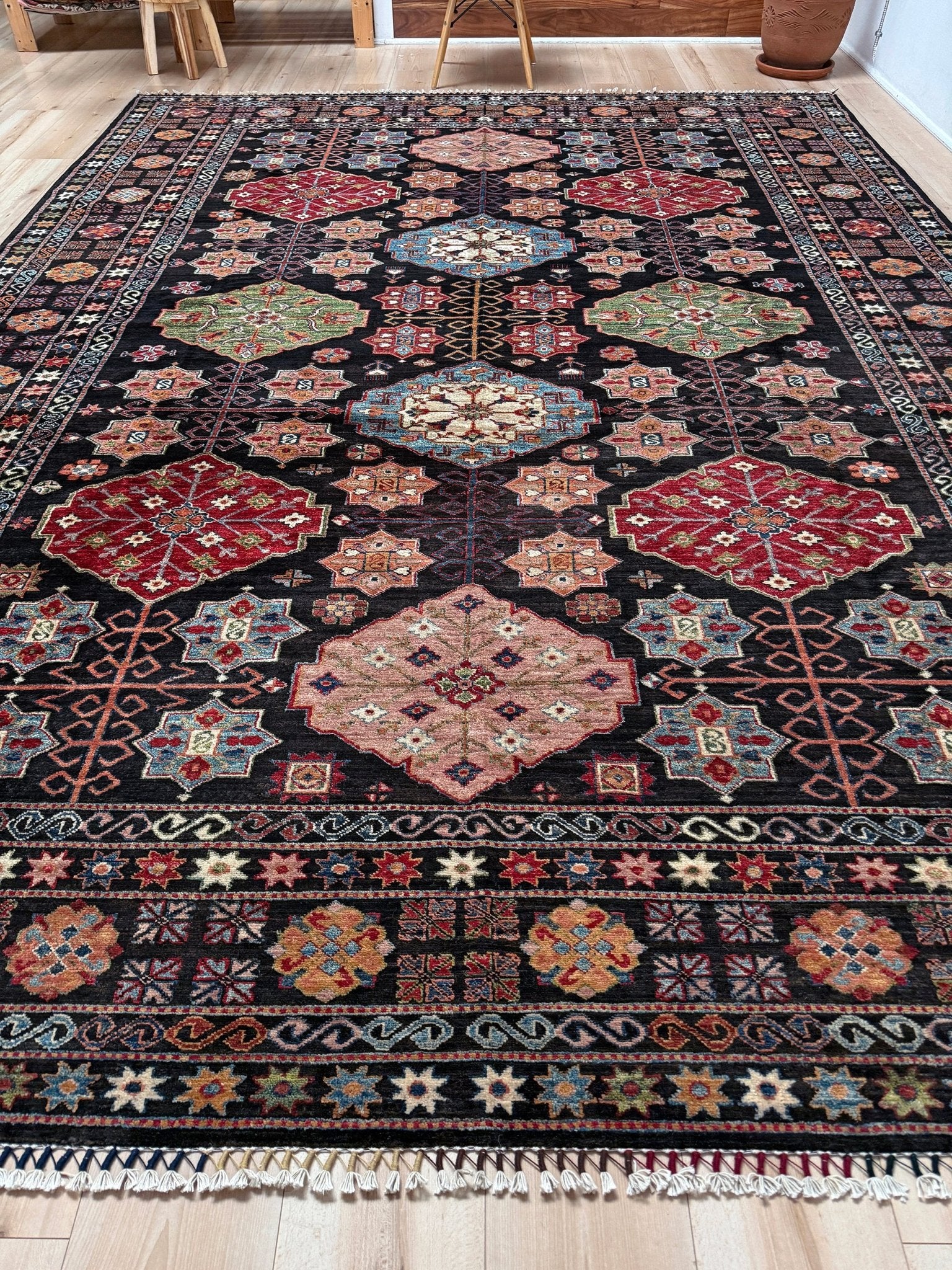 Handmade Turkmen-style 9x12 wool rug with Caucasian-inspired design, rich black, crimson, ivory, and sage hues. Luxury area rug with intricate medallions and floral motifs, perfect for bedroom, living room, or dining room. High-quality craftsmanship from the best rug shop in Burlingame CA, SF Bay Area. Free shipping, timeless character, and elegance for any space.