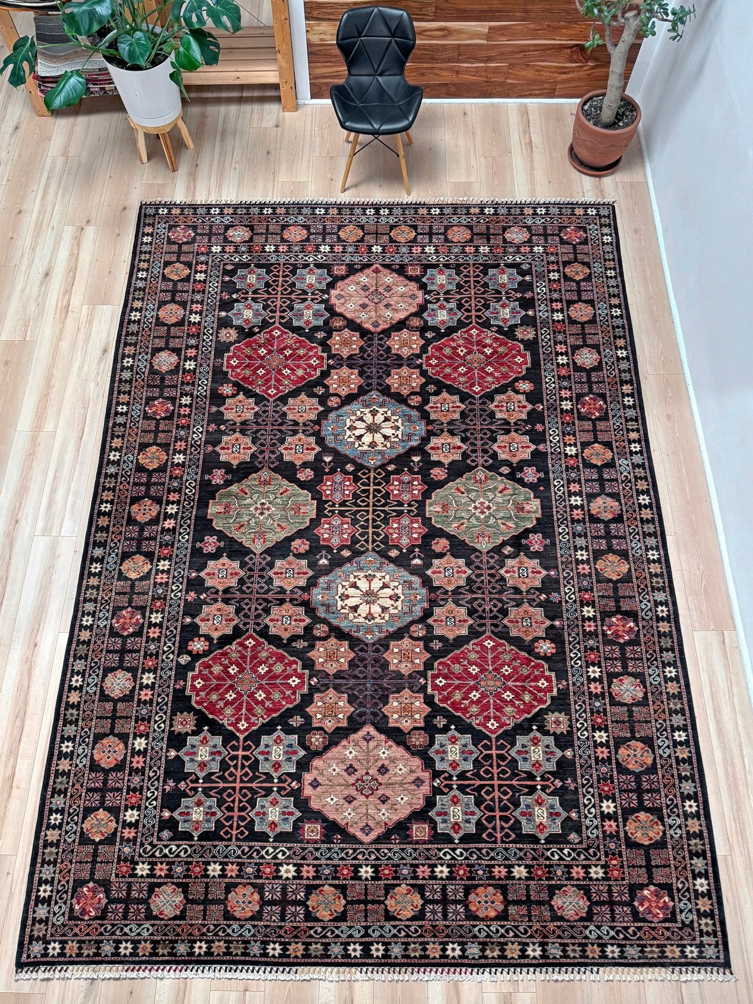 Handmade Turkmen-style 9x12 wool rug with Caucasian-inspired design, rich black, crimson, ivory, and sage hues. Luxury area rug with intricate medallions and floral motifs, perfect for bedroom, living room, or dining room. High-quality craftsmanship from the best rug shop in Burlingame CA, SF Bay Area. Free shipping, timeless character, and elegance for any space.