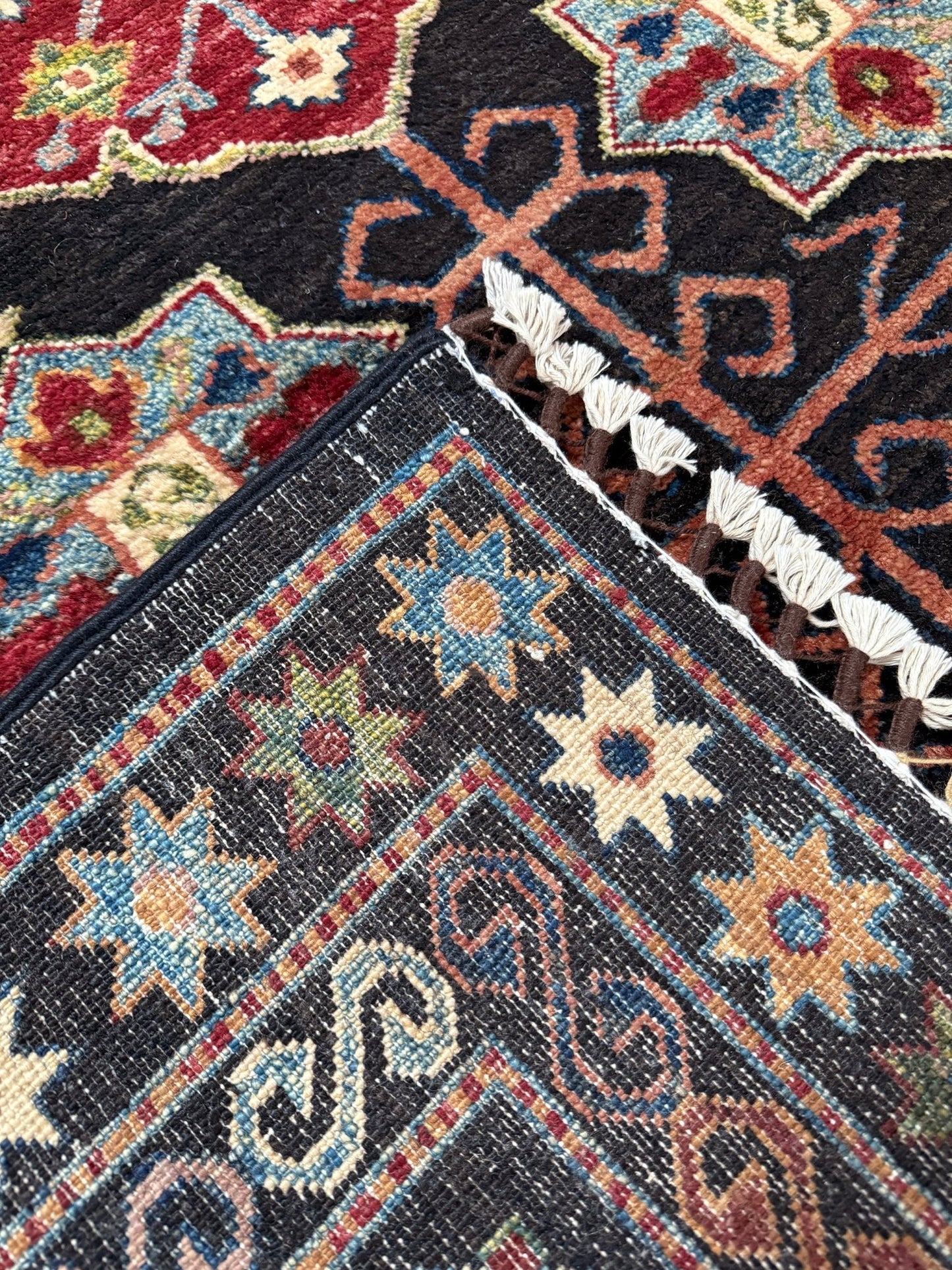 Handmade Turkmen-style 9x12 wool rug with Caucasian-inspired design, rich black, crimson, ivory, and sage hues. Luxury area rug with intricate medallions and floral motifs, perfect for bedroom, living room, or dining room. High-quality craftsmanship from the best rug shop in Burlingame CA, SF Bay Area. Free shipping, timeless character, and elegance for any space.