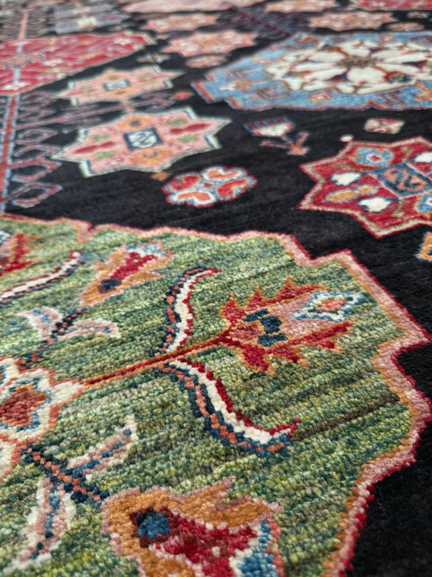 Handmade Turkmen-style 9x12 wool rug with Caucasian-inspired design, rich black, crimson, ivory, and sage hues. Luxury area rug with intricate medallions and floral motifs, perfect for bedroom, living room, or dining room. High-quality craftsmanship from the best rug shop in Burlingame CA, SF Bay Area. Free shipping, timeless character, and elegance for any space.