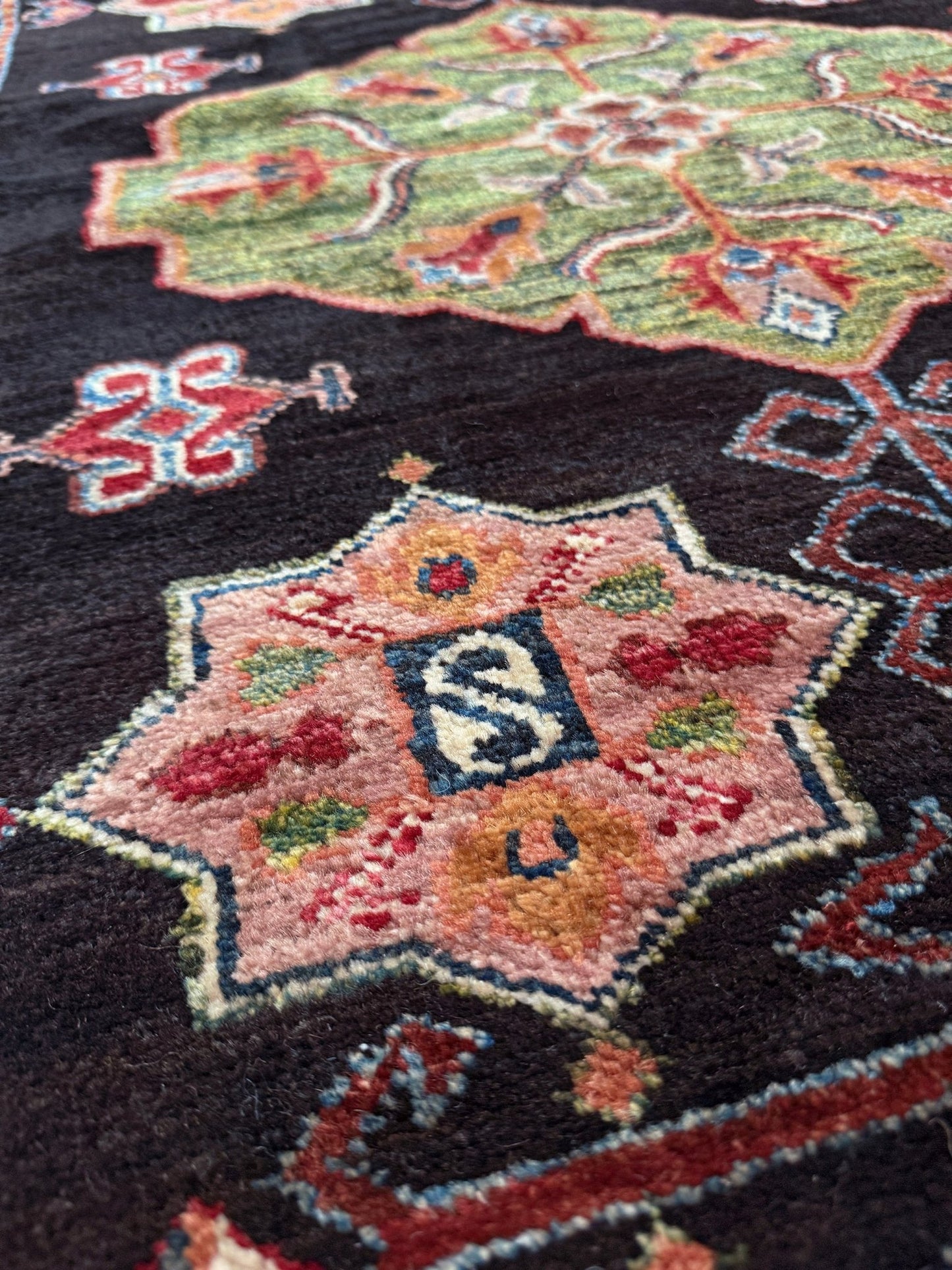 Handmade Turkmen-style 9x12 wool rug with Caucasian-inspired design, rich black, crimson, ivory, and sage hues. Luxury area rug with intricate medallions and floral motifs, perfect for bedroom, living room, or dining room. High-quality craftsmanship from the best rug shop in Burlingame CA, SF Bay Area. Free shipping, timeless character, and elegance for any space.