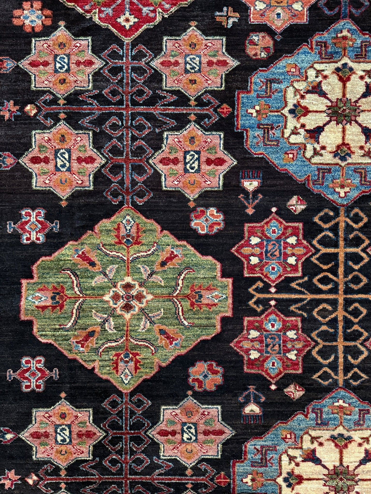 Handmade Turkmen-style 9x12 wool rug with Caucasian-inspired design, rich black, crimson, ivory, and sage hues. Luxury area rug with intricate medallions and floral motifs, perfect for bedroom, living room, or dining room. High-quality craftsmanship from the best rug shop in Burlingame CA, SF Bay Area. Free shipping, timeless character, and elegance for any space.