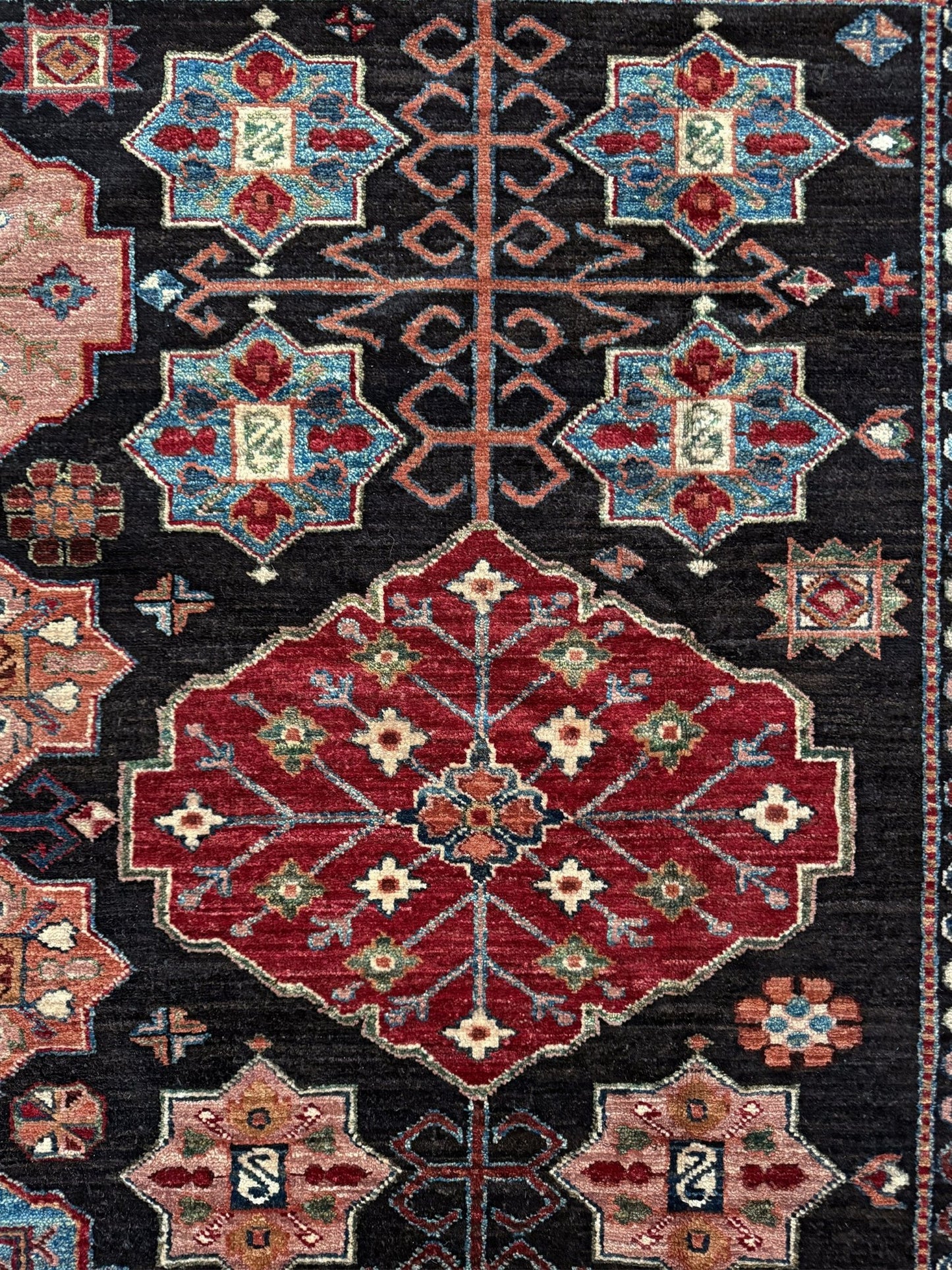 Handmade Turkmen-style 9x12 wool rug with Caucasian-inspired design, rich black, crimson, ivory, and sage hues. Luxury area rug with intricate medallions and floral motifs, perfect for bedroom, living room, or dining room. High-quality craftsmanship from the best rug shop in Burlingame CA, SF Bay Area. Free shipping, timeless character, and elegance for any space.