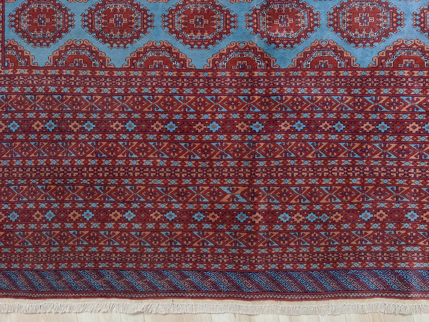 Vintage Uzbek Bukhara rug with sky blue field and repeating brick red gul motifs, navy borders, large handmade merino wool area rug 10x14 with velvety pile from Indigo Rugs Burlingame Bay Area