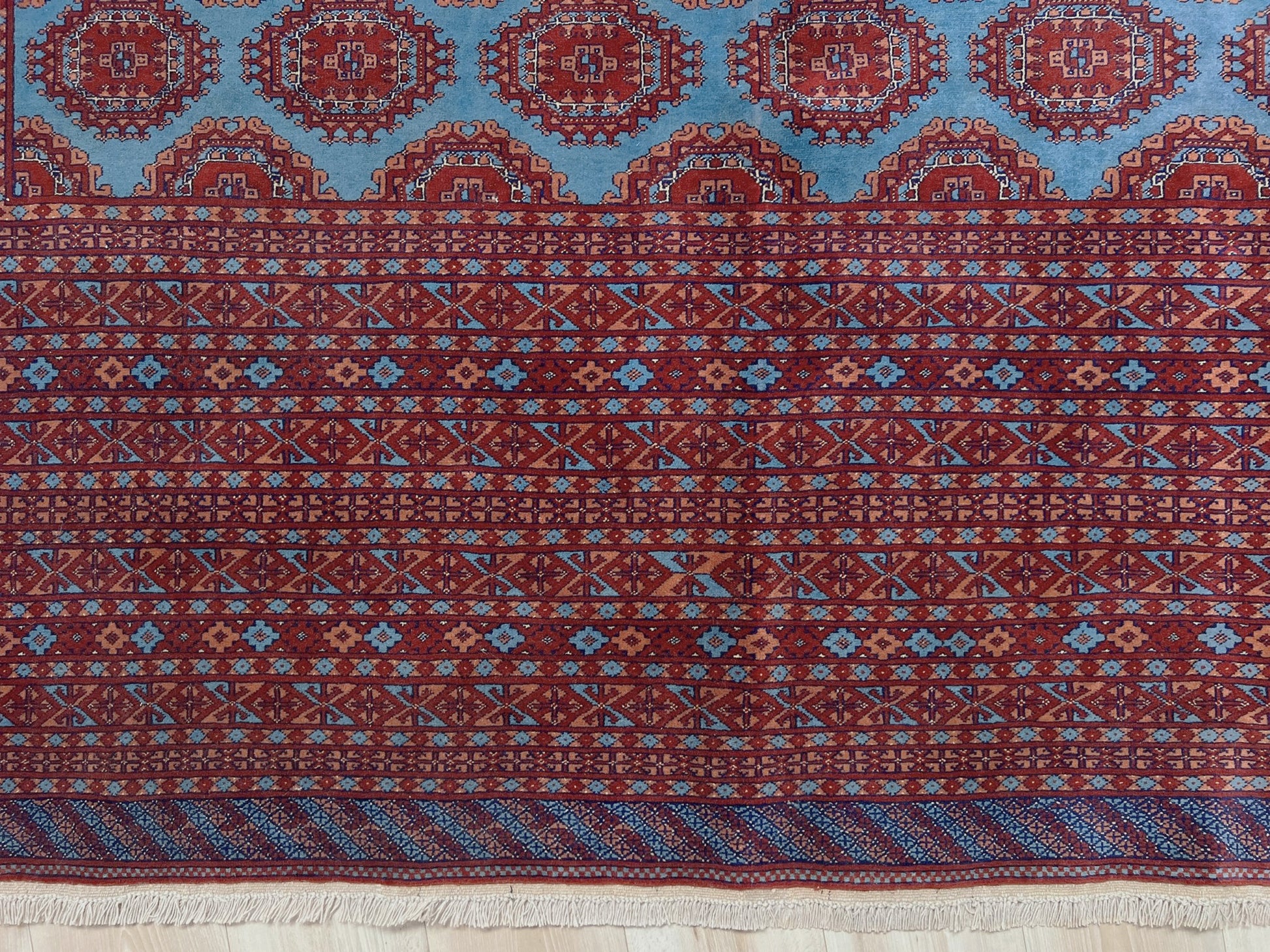 Vintage Uzbek Bukhara rug with sky blue field and repeating brick red gul motifs, navy borders, large handmade merino wool area rug 10x14 with velvety pile from Indigo Rugs Burlingame Bay Area