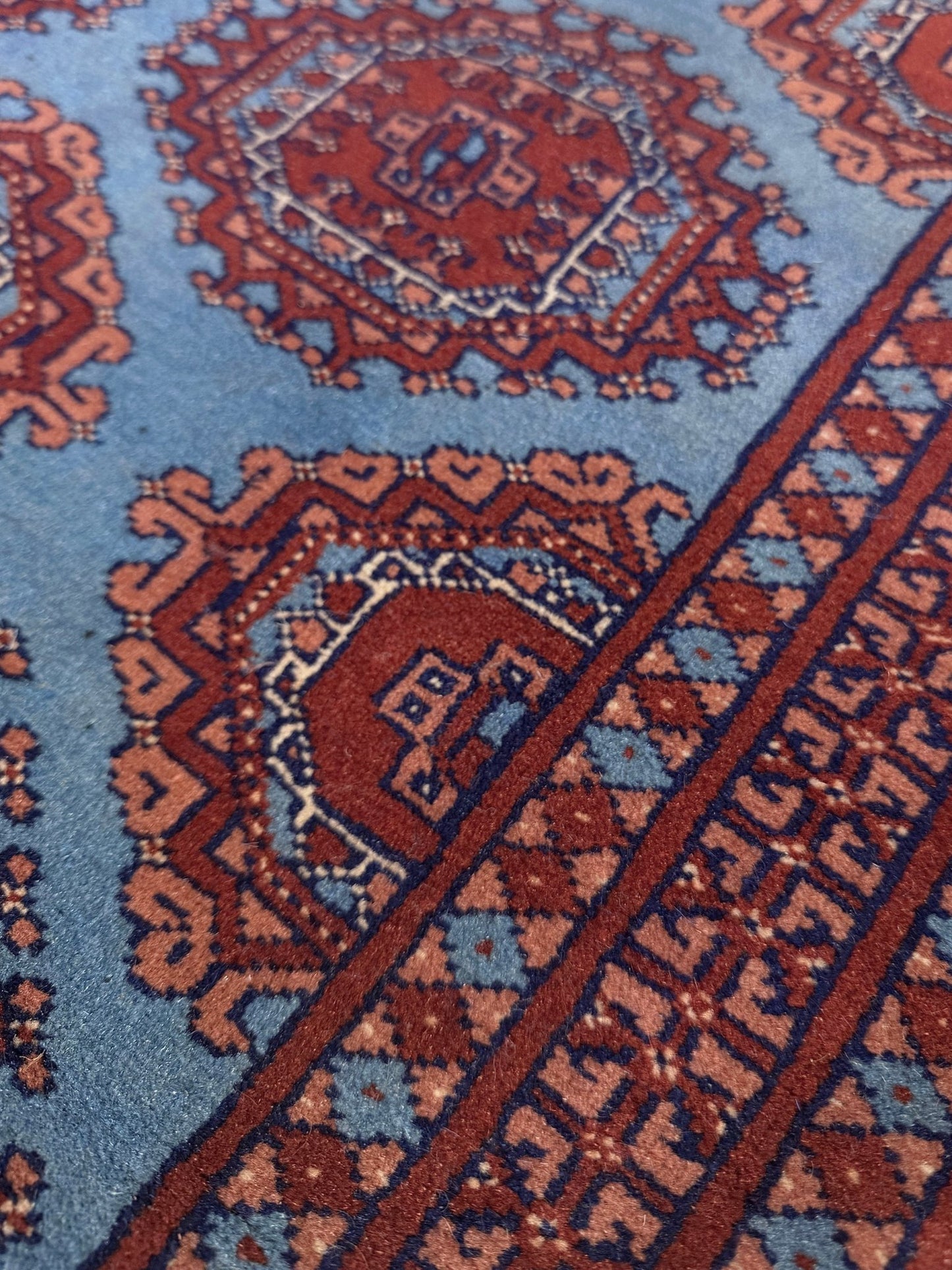 Vintage Uzbek Bukhara rug with sky blue field and repeating brick red gul motifs, navy borders, large handmade merino wool area rug 10x14 with velvety pile from Indigo Rugs Burlingame Bay Area