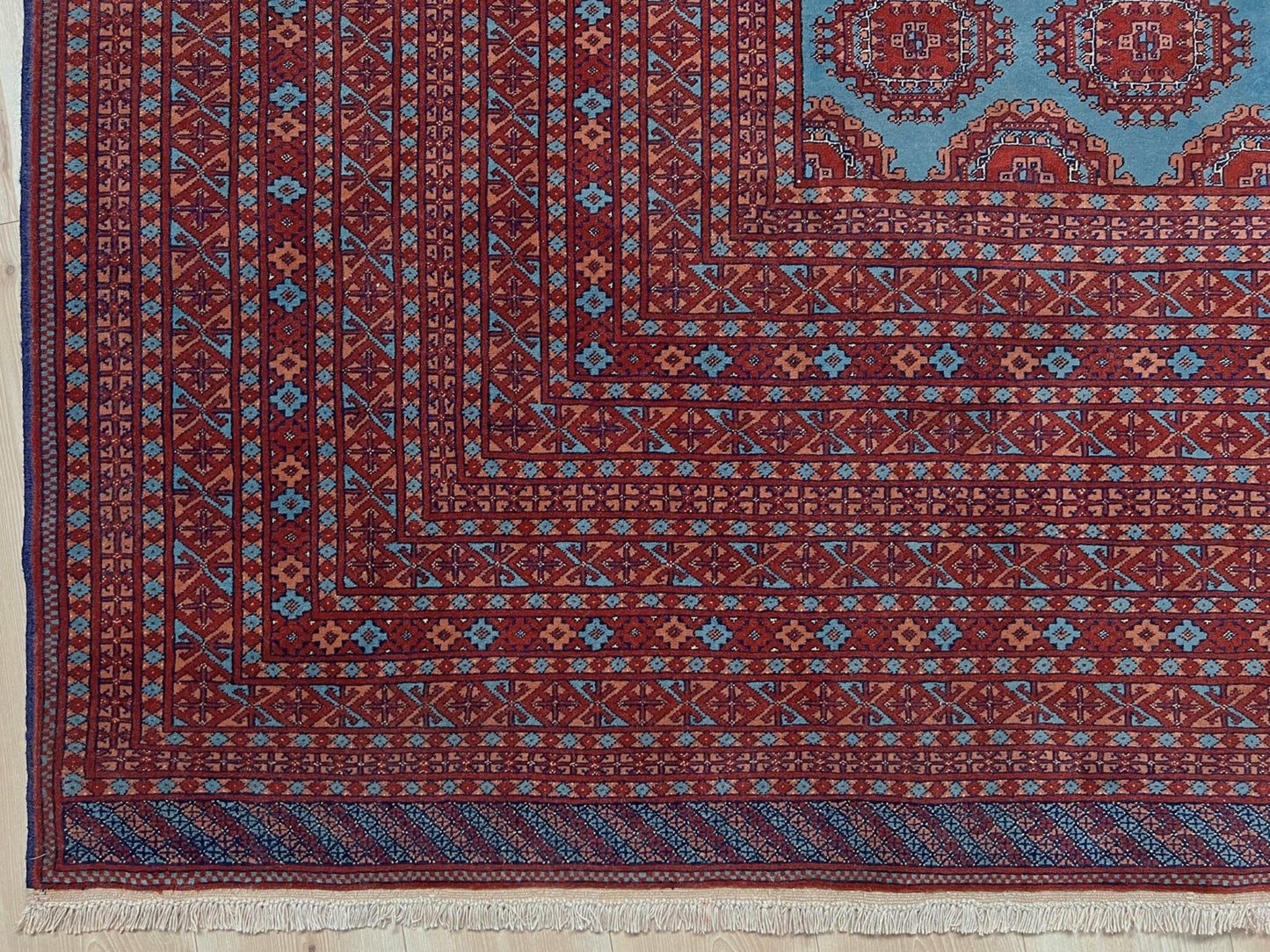 Vintage Uzbek Bukhara rug with sky blue field and repeating brick red gul motifs, navy borders, large handmade merino wool area rug 10x14 with velvety pile from Indigo Rugs Burlingame Bay Area