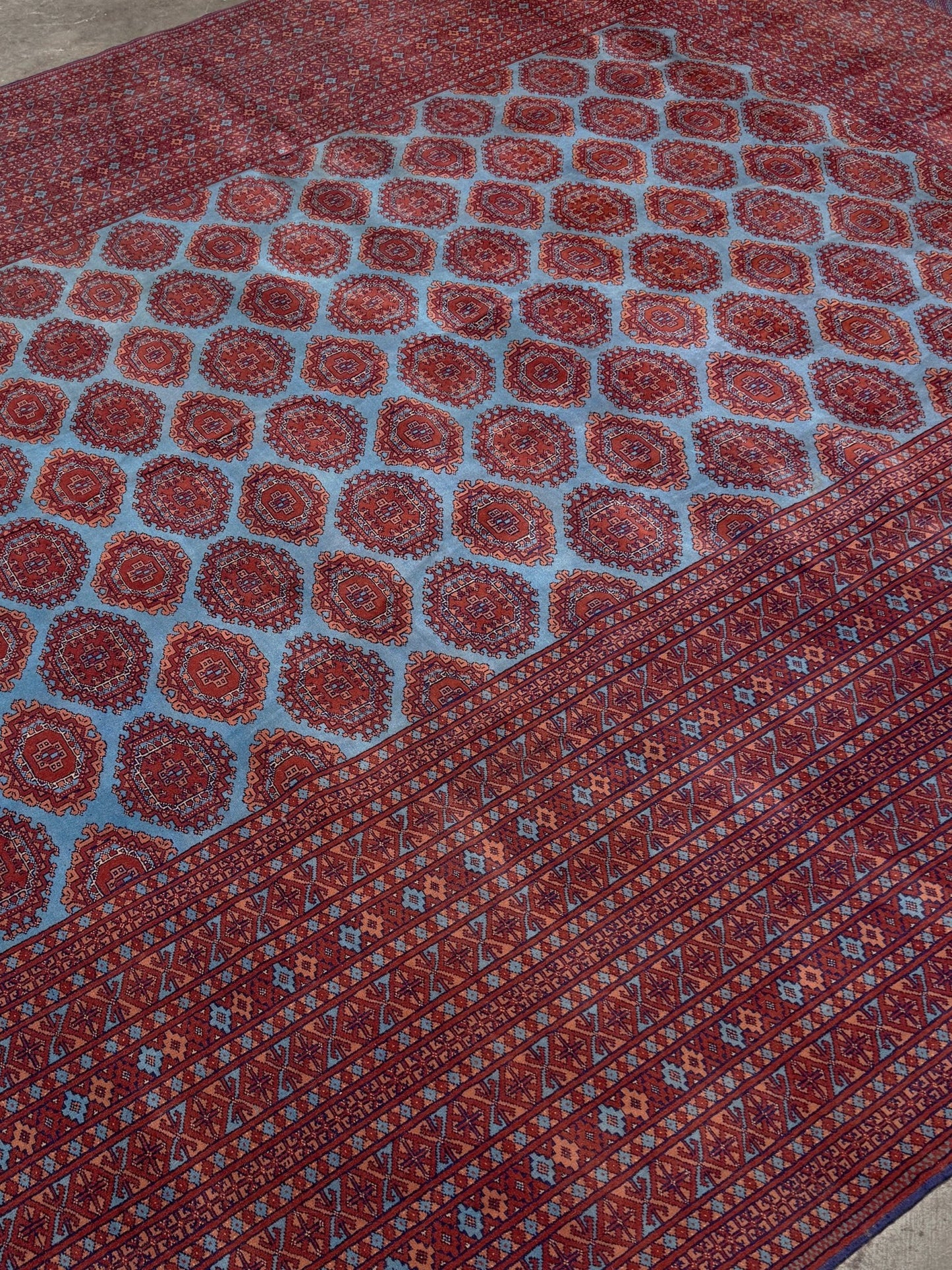 Vintage Uzbek Bukhara rug with sky blue field and repeating brick red gul motifs, navy borders, large handmade merino wool area rug 10x14 with velvety pile from Indigo Rugs Burlingame Bay Area
