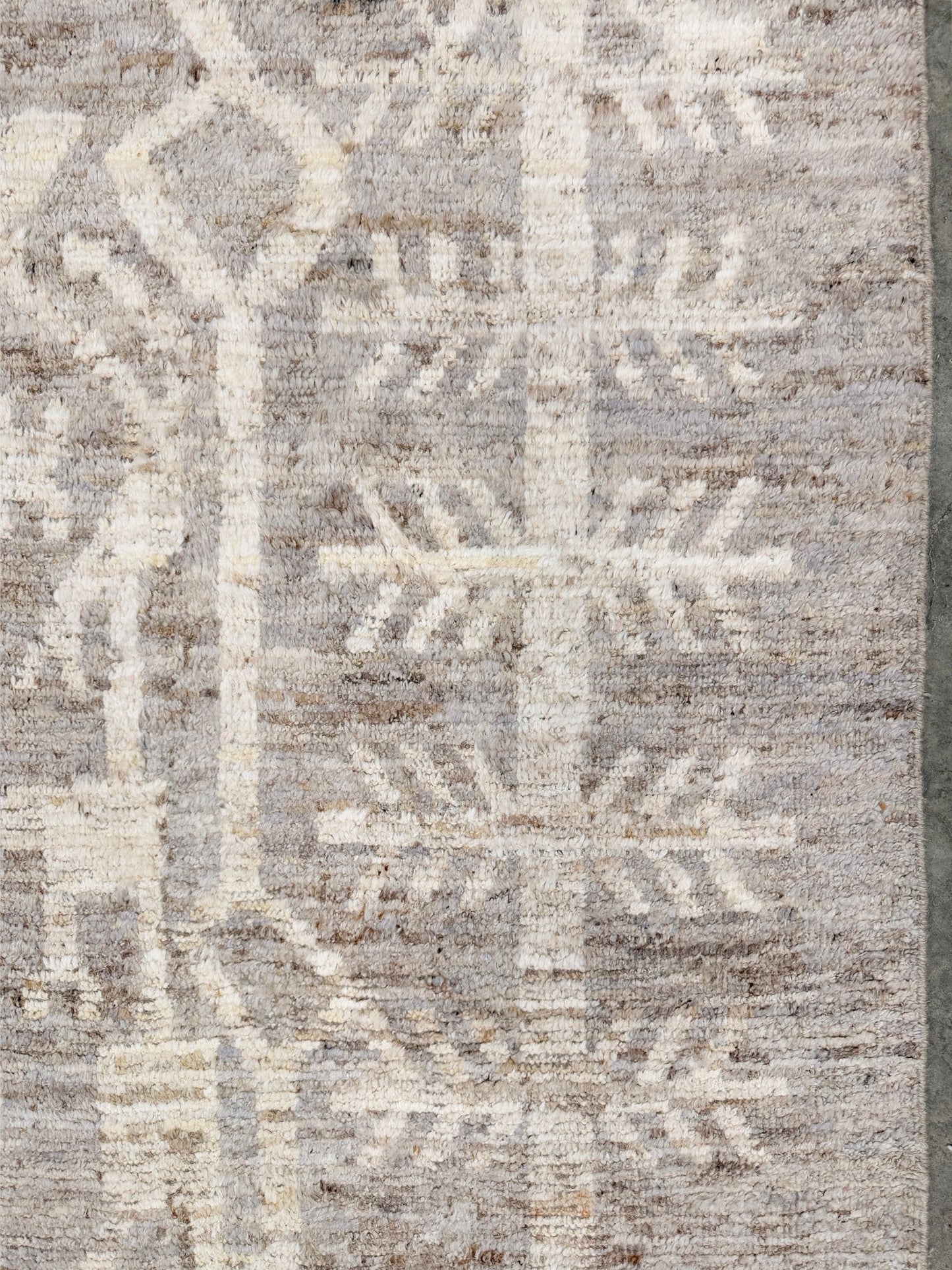 Textured area rug with a geometric pattern in neutral colors. Brand new 9x12 Turkish Tulu Organic Modern  rug with warm greige field, soft ivory abstract tribal motifs, taupe and oatmeal tones, handmade wool area rug from Indigo Rugs Burlingame Bay Area.