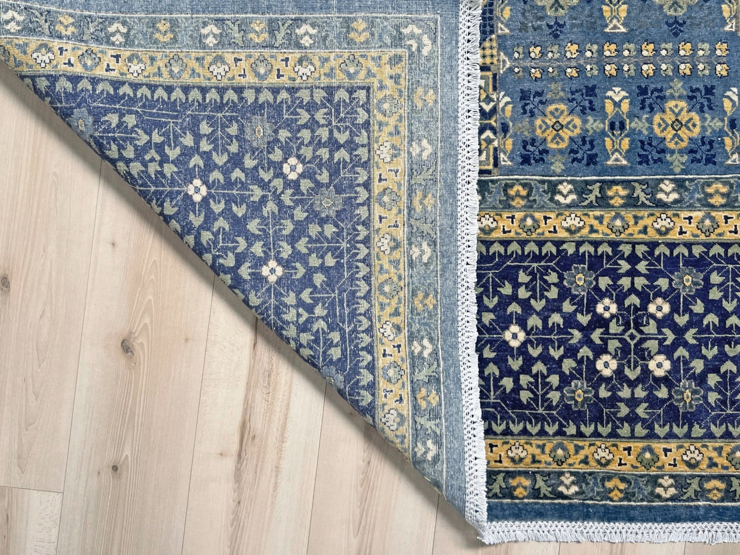Decorative blue and gold rug with intricate patterns on a wooden floor. Brand new fine Mamluk rug 10x14 with navy, denim blue, and soft gold geometric medallion design, high knot density (50×50 ~156 KPSI), perfect for large living rooms and dining spaces. From Indigo Rugs, Burlingame — the best rug shop in the San Francisco Bay Area. Free shipping.