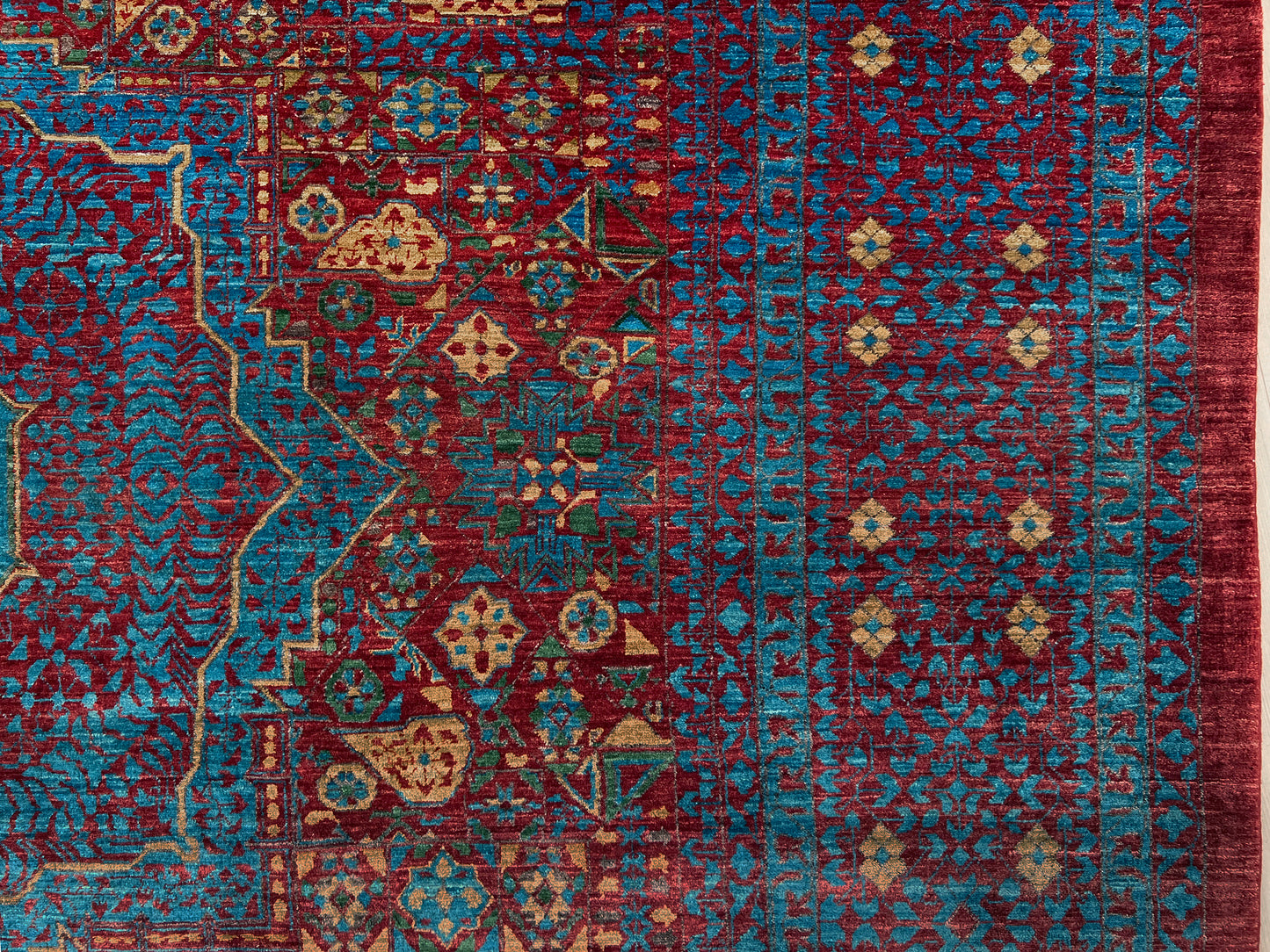 Regal Mamluk area rug made from luxurious Ghazni wool, featuring a rich color combination of deep reds, blues, golds, and greens. This handmade carpet showcases intricate geometric patterns and medallions, adding elegance and sophistication to any living room, bedroom, dining area, or office. Available from the best rug shop in the San Francisco Bay Area, this luxury rug comes with free shipping across the U.S.