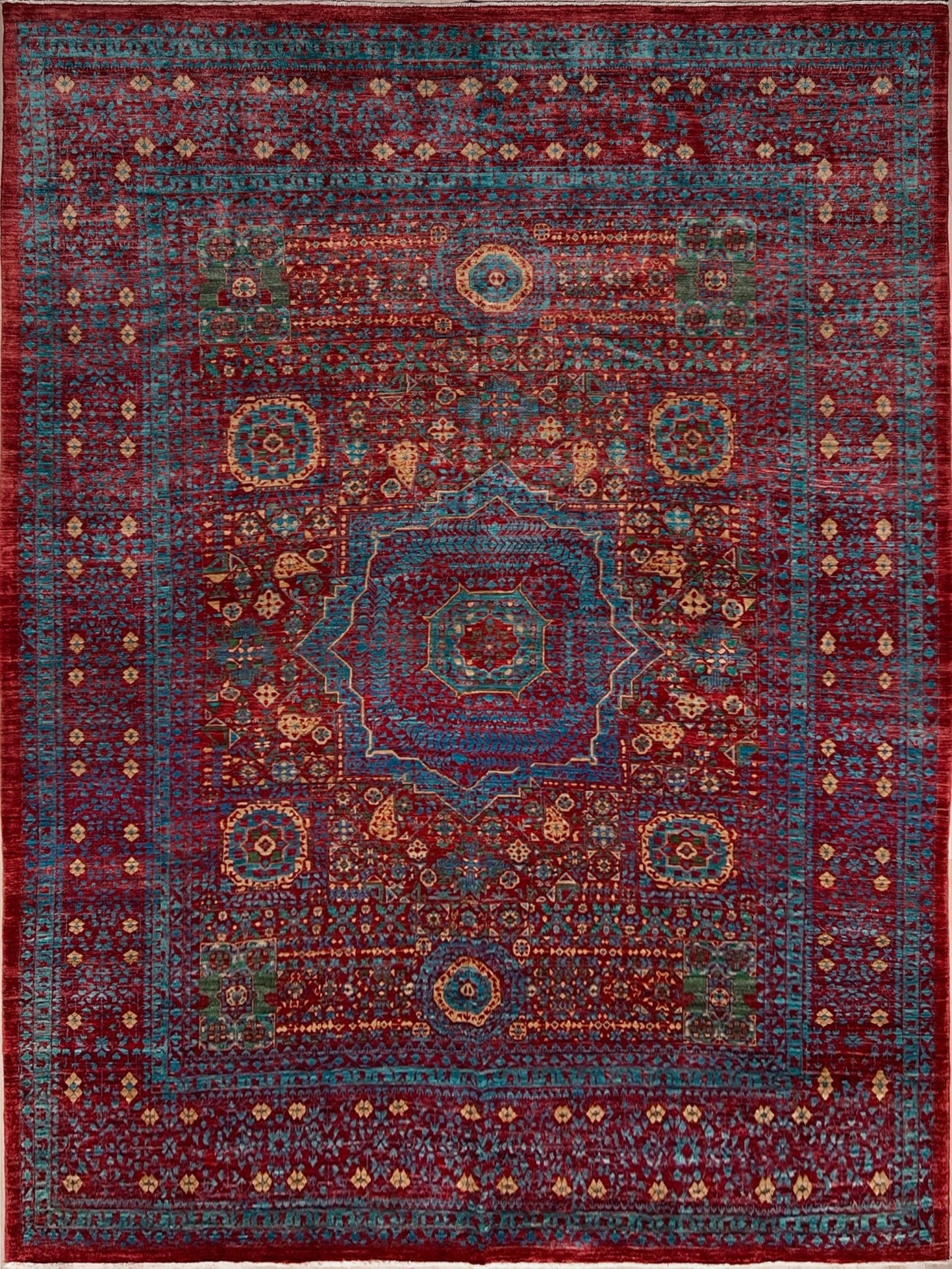 Regal Mamluk area rug made from luxurious Ghazni wool, featuring a rich color combination of deep reds, blues, golds, and greens. This handmade carpet showcases intricate geometric patterns and medallions, adding elegance and sophistication to any living room, bedroom, dining area, or office. Available from the best rug shop in the San Francisco Bay Area, this luxury rug comes with free shipping across the U.S.